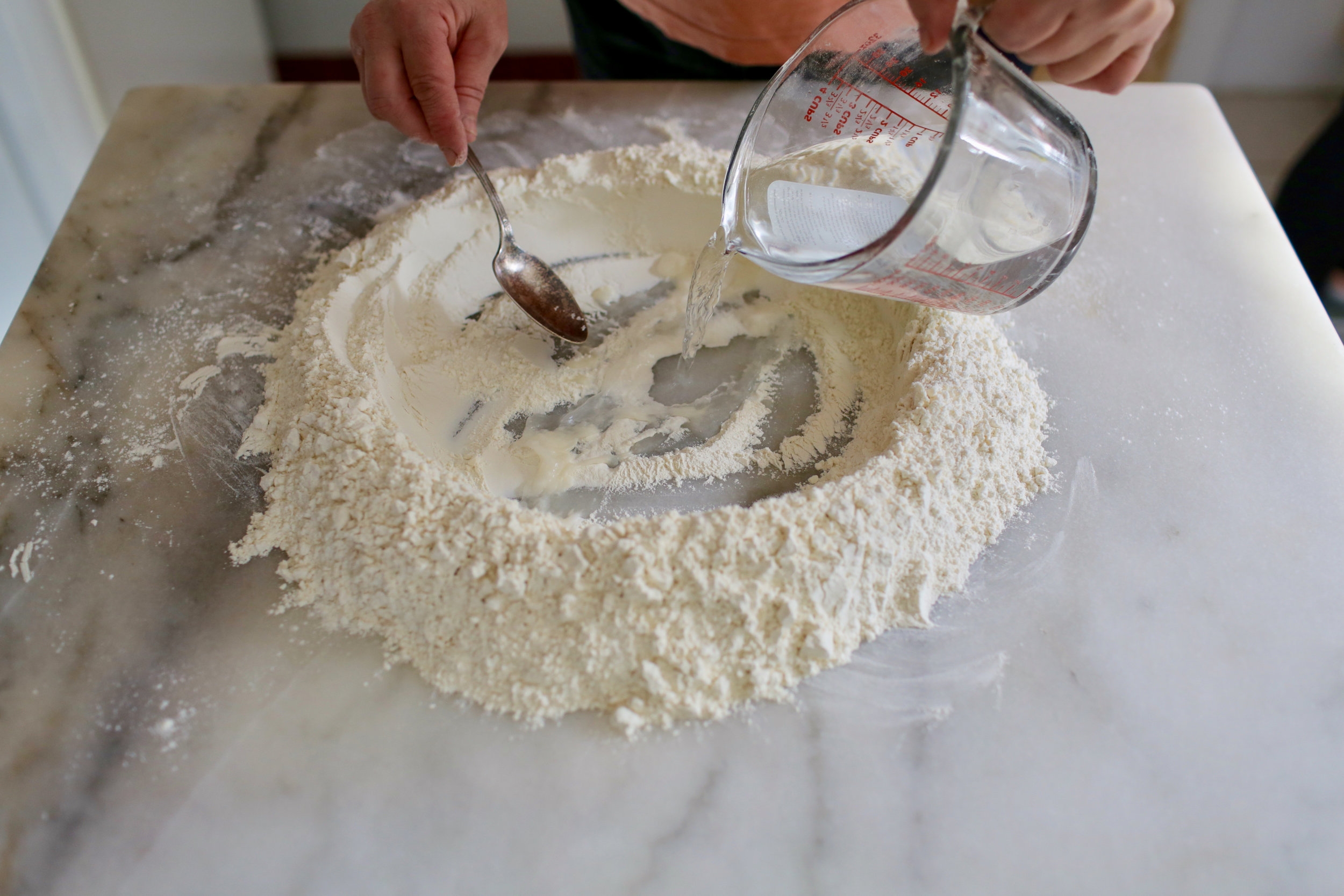  1. For dough, make a well in the flour and add water and salt.&nbsp; 
