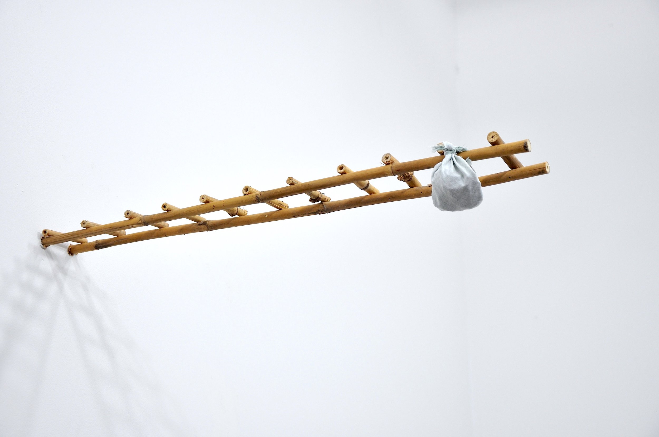   Extract (escape ladder) , 2017, fabricated bamboo ladder toy, cloth, stones, dimensions: variable 