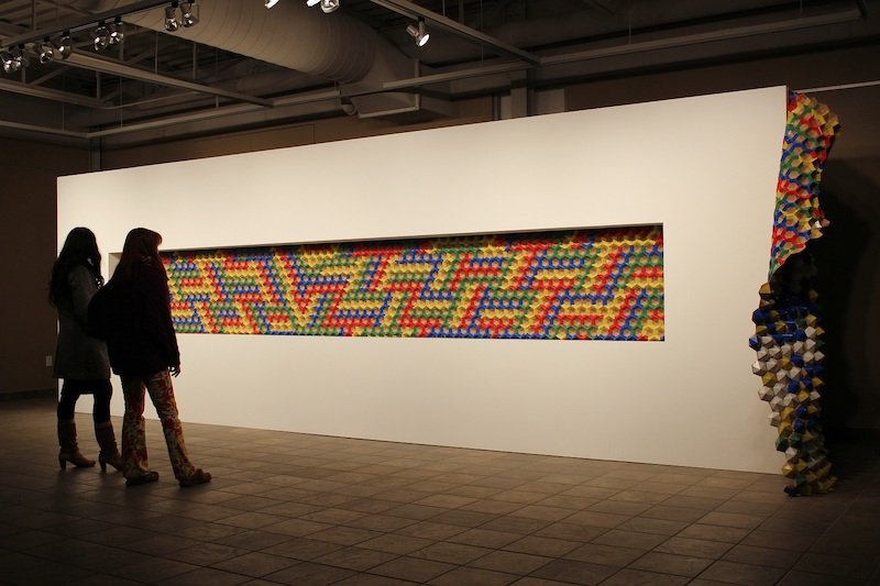   Camouflage in the Age of , 2014, Dieppe Arts Center, Moncton, Canada   Colored duct tape, recycled cardboard, wood.   315 x 91 x 31 inches  Photo credit: Jeffrey Poirier 