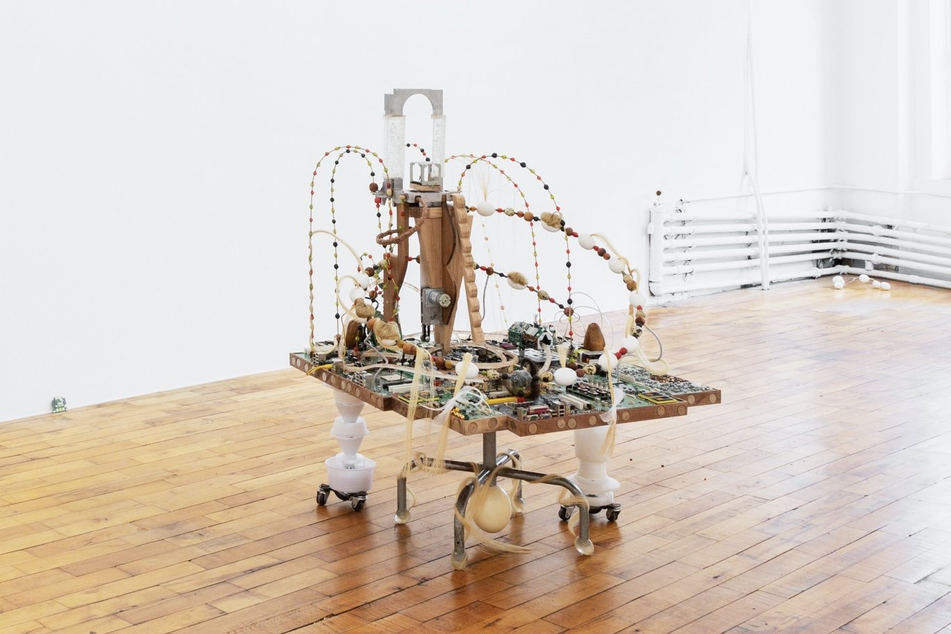   Metropolis Series: Good Egg Community,  2022, Britannia pewter, seeds, foraged electronic components, reclaimed resin, eggs, horse hair, crickets, motor, human hair, quarters, reclaimed oak and walnut, 49 x 46 x 45” 