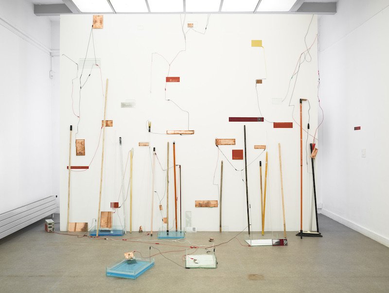  Maxime Bagni,  Their Broom (2) , 2022, Broomsticks, power supply glass, cable network, copper, aluminium, salt, 124.8 x 156”&nbsp; 