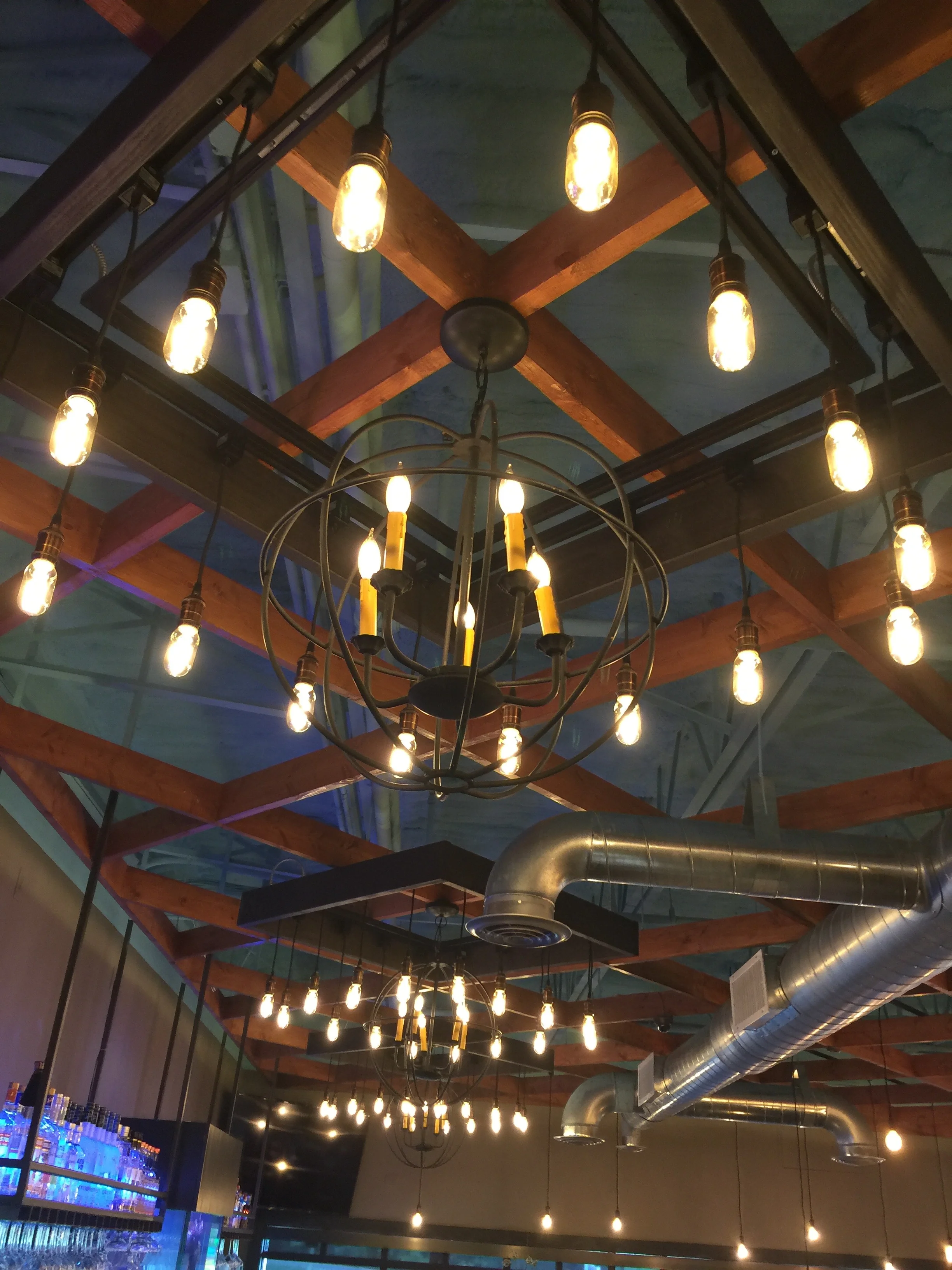 3 Custom Fabricated Filament Bulb Chandeliers over Bar
