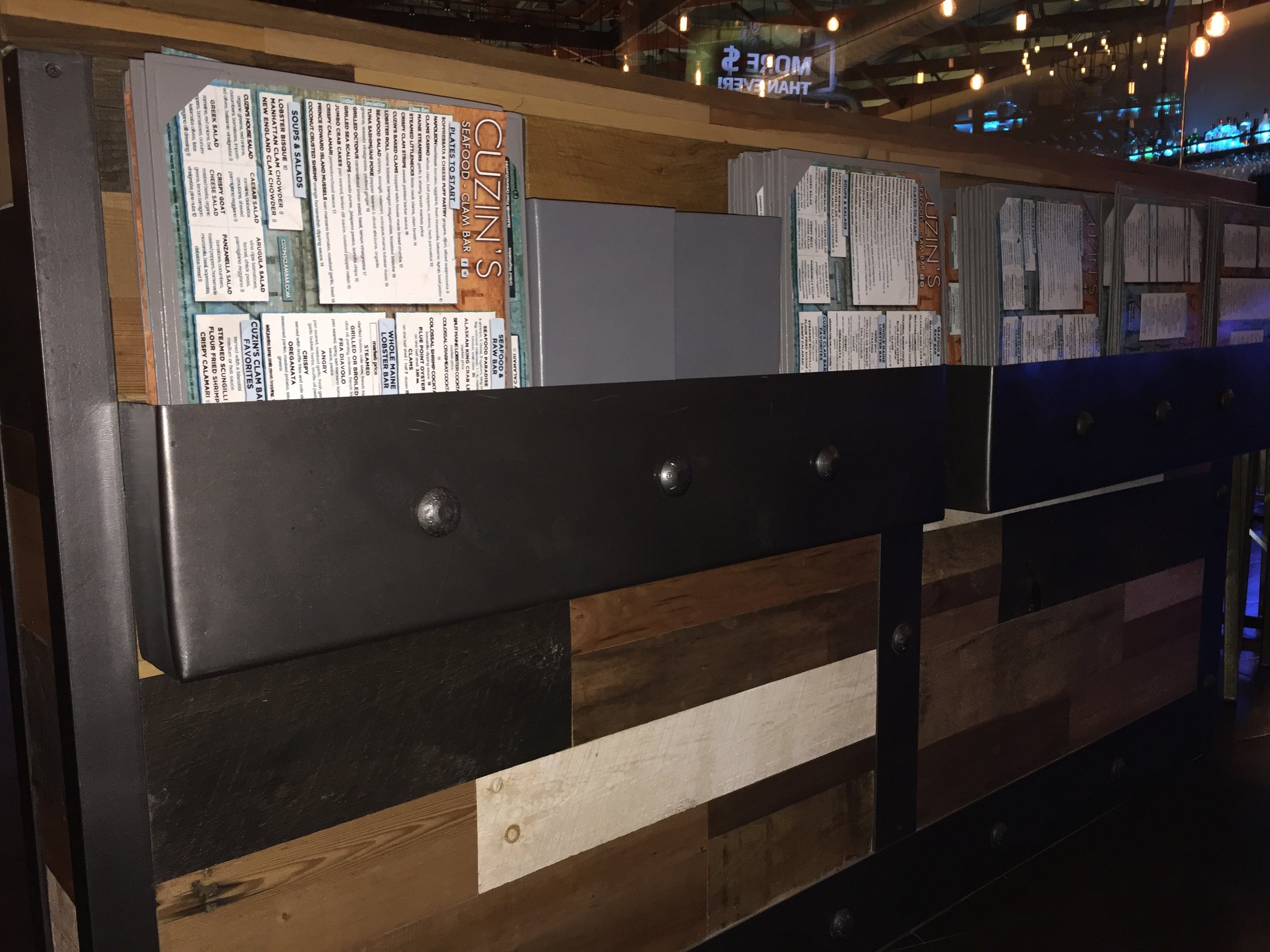 Menus Stored in Steel Riveted Holders on Reclaimed Barn Wood Knee-wall supporting Glass Partition