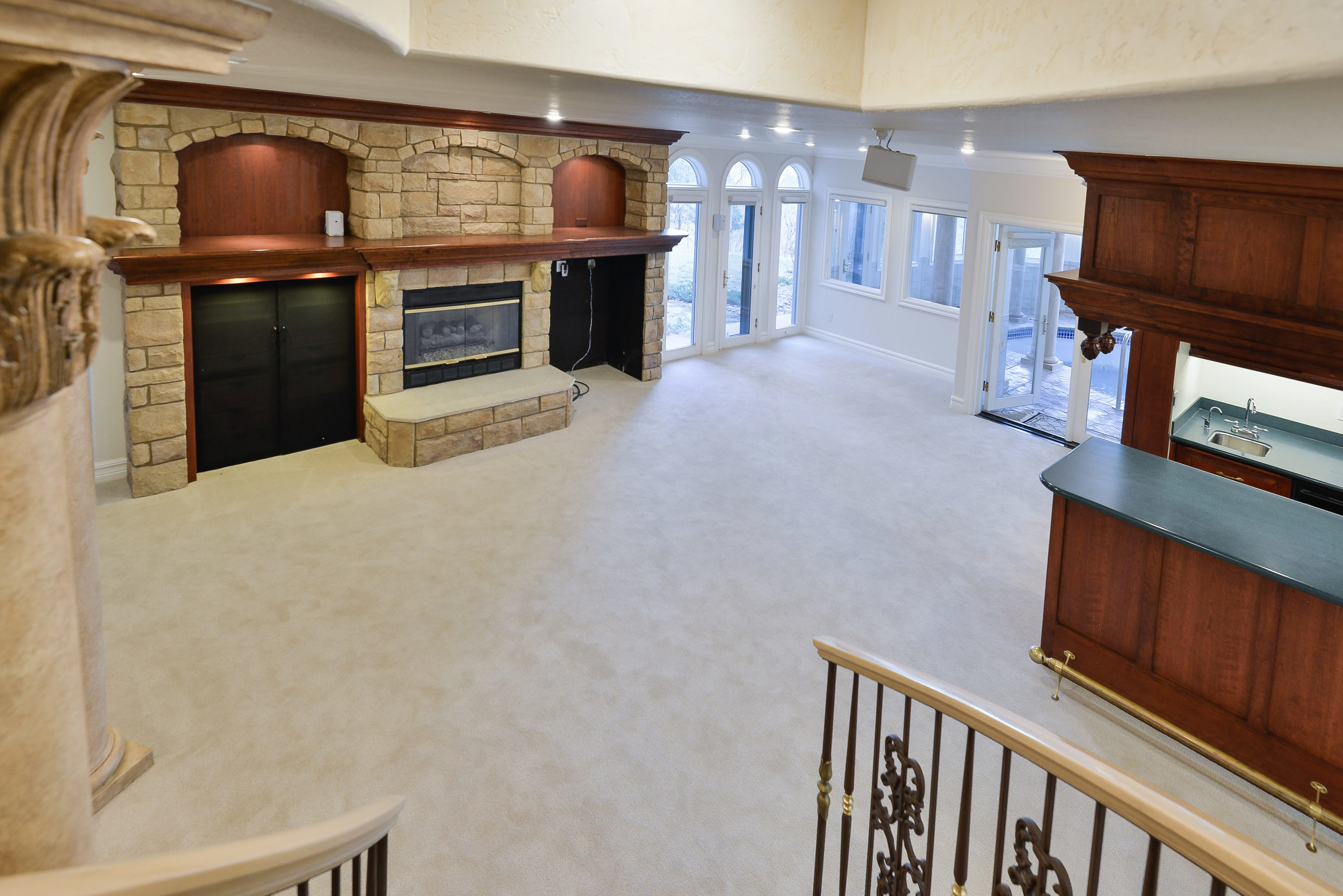 20 - Family room in lower level w fireplace, wet bar and game area.jpg