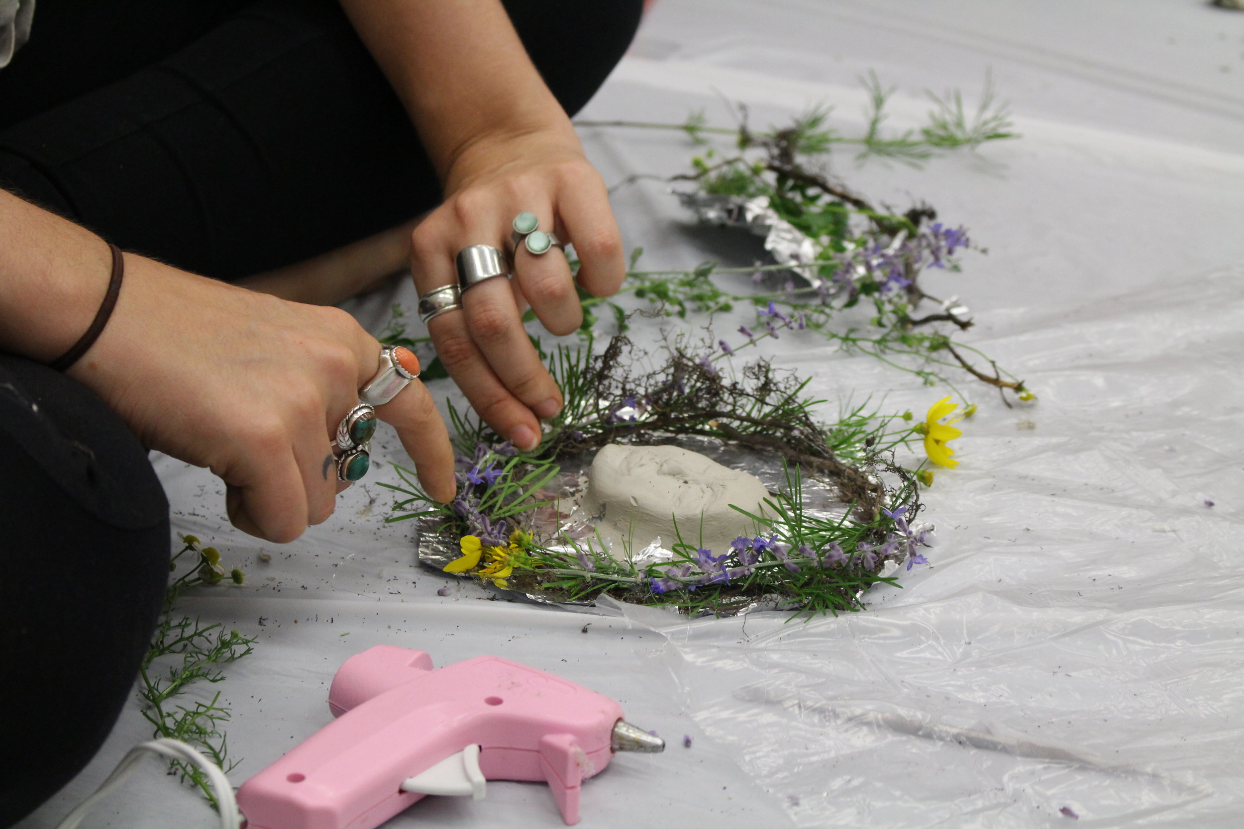 up close picture of clay work using foil and parts of a plant