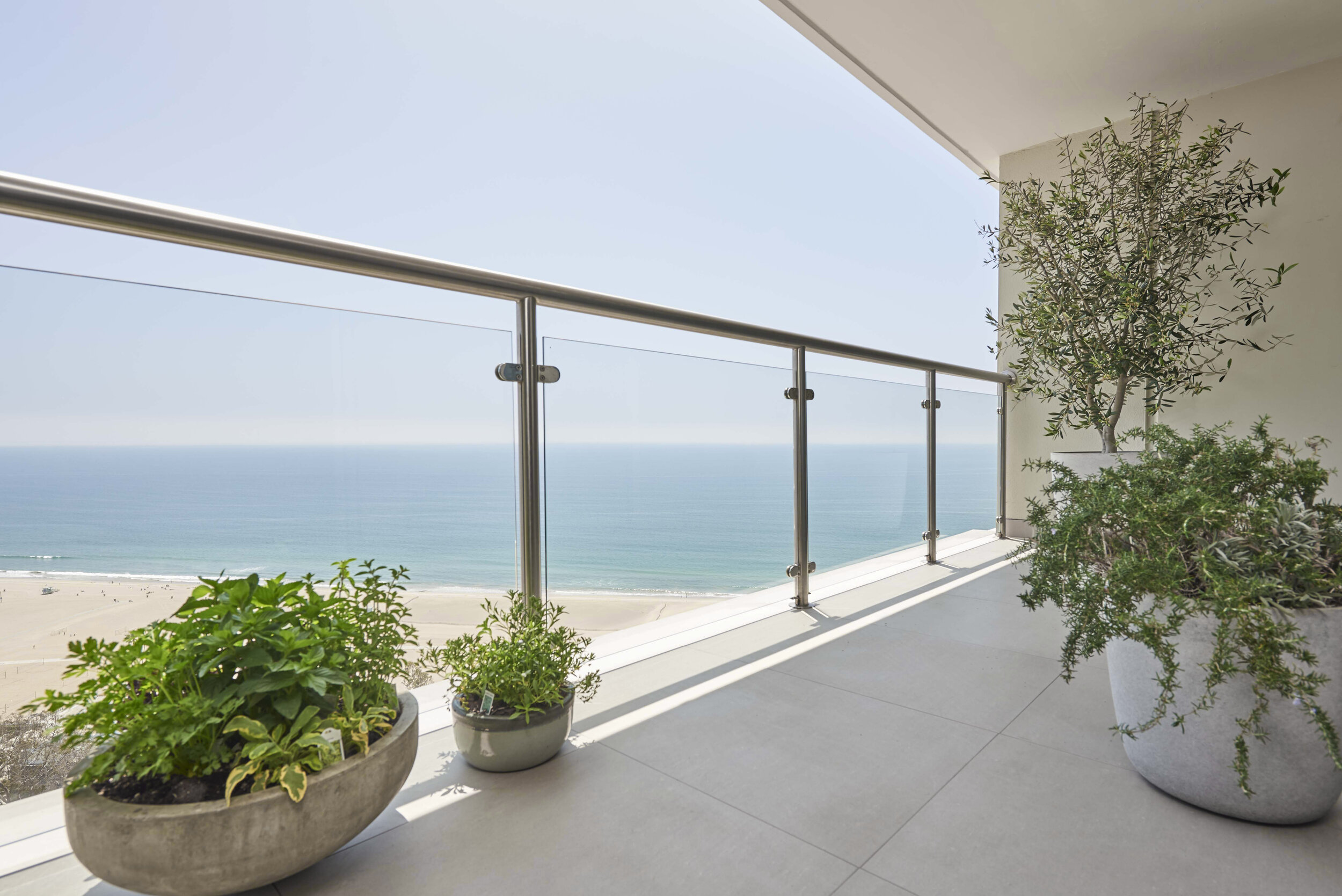 patio with plants in concrete planters overlooking ocean
