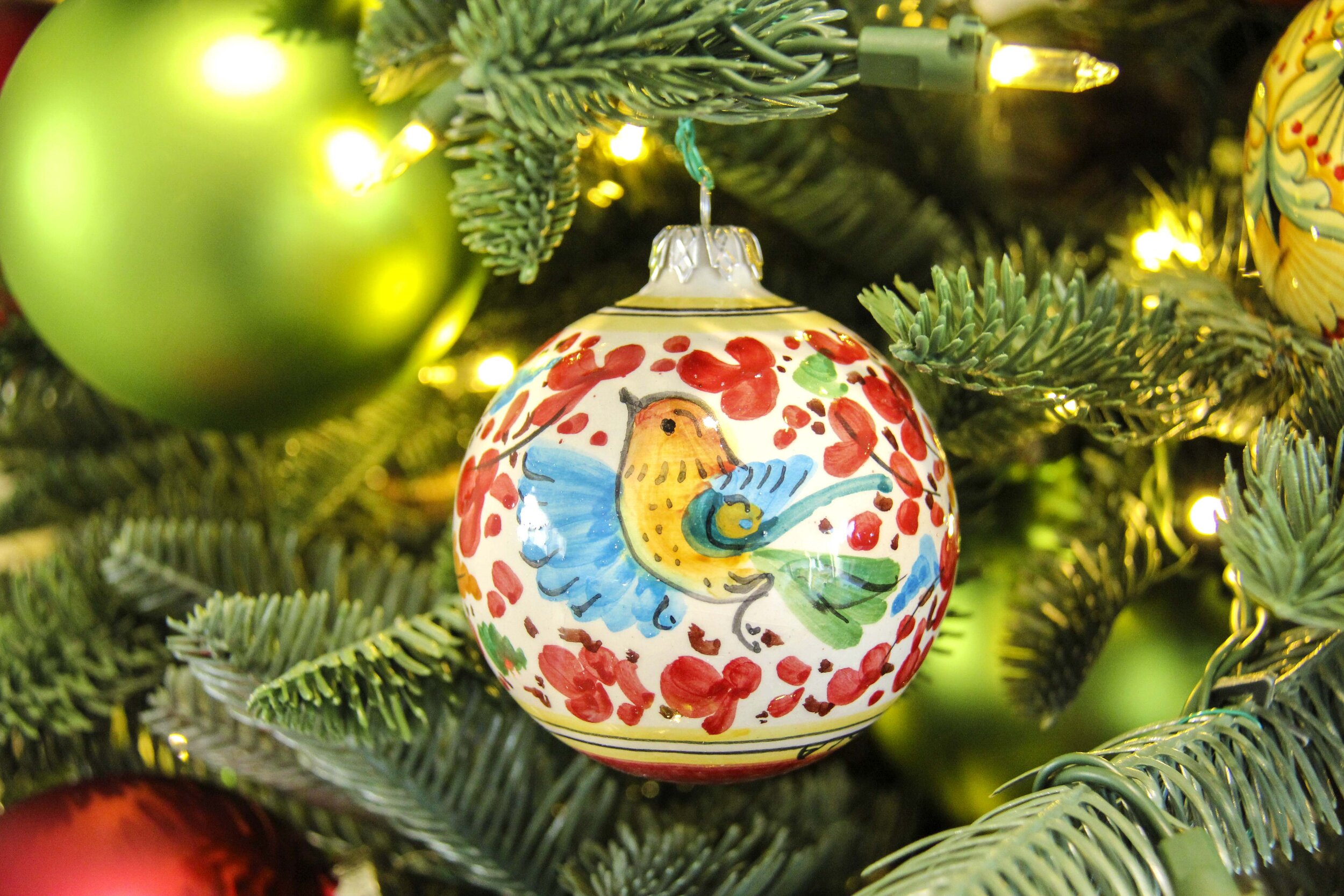 Round ornament painted with a bird design on a tree