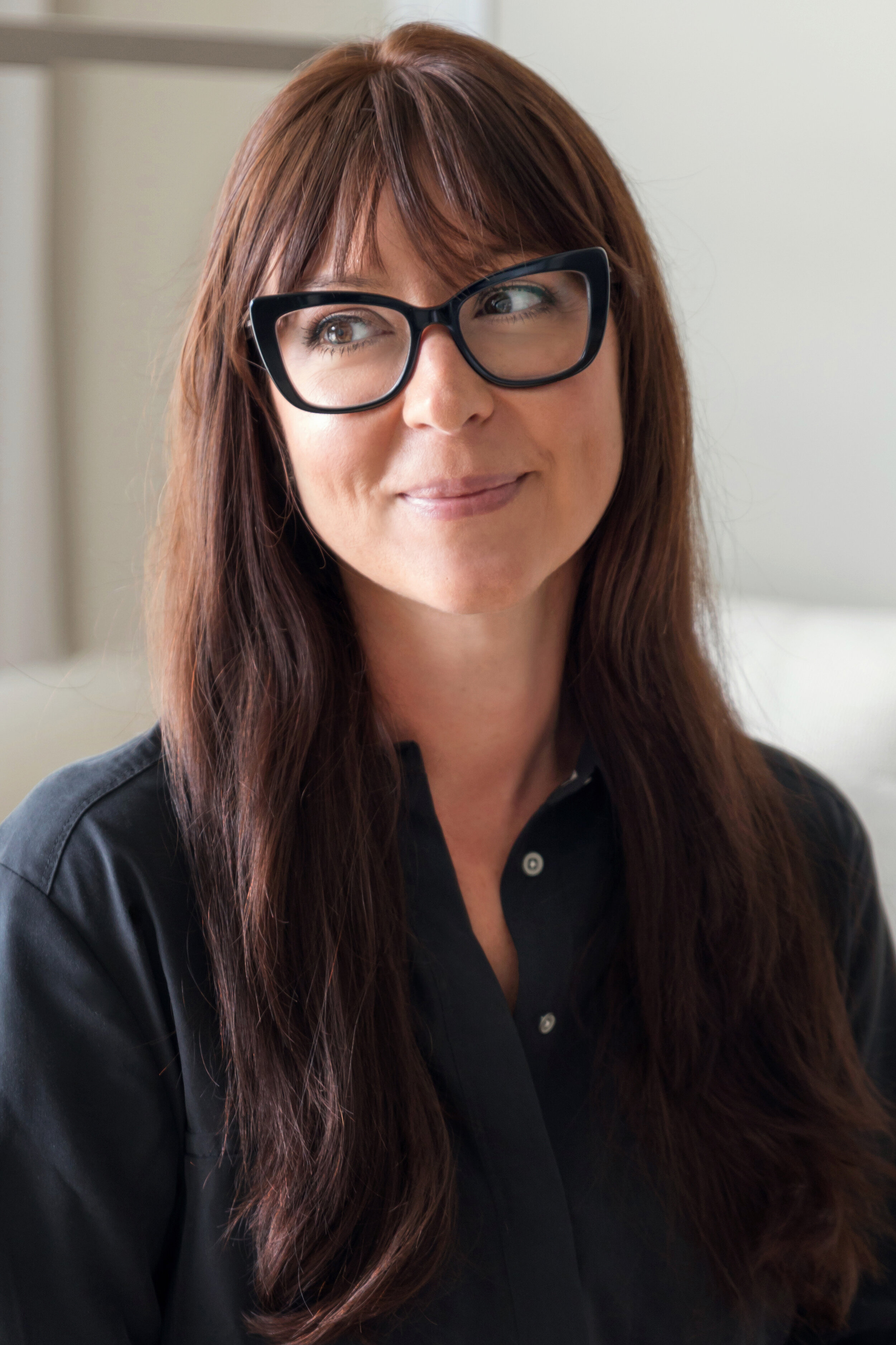 Sarah Barnard in black shirt with glasses and long brown hair