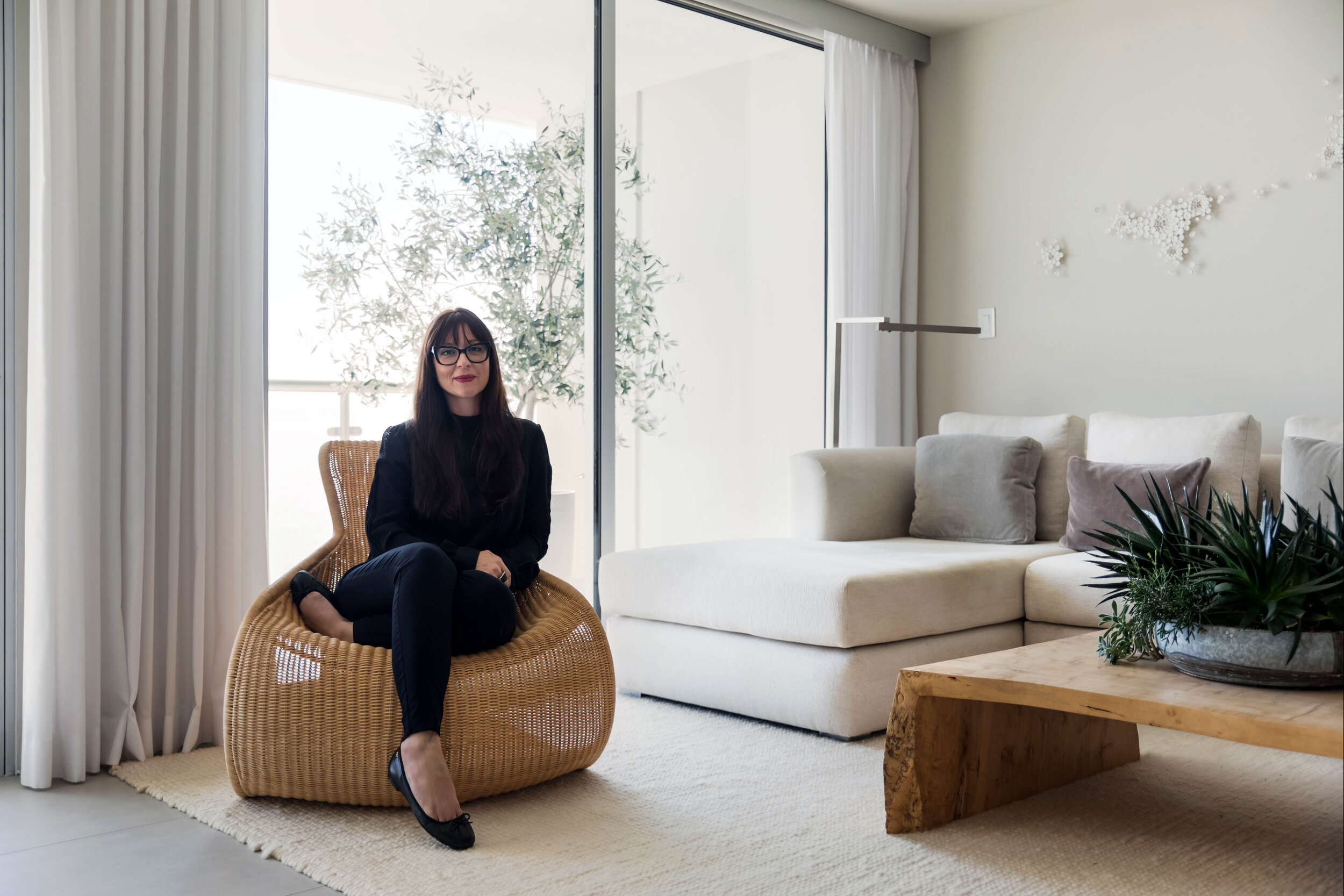 Designer Sarah Barnard seated in contemporary minimalist condo.