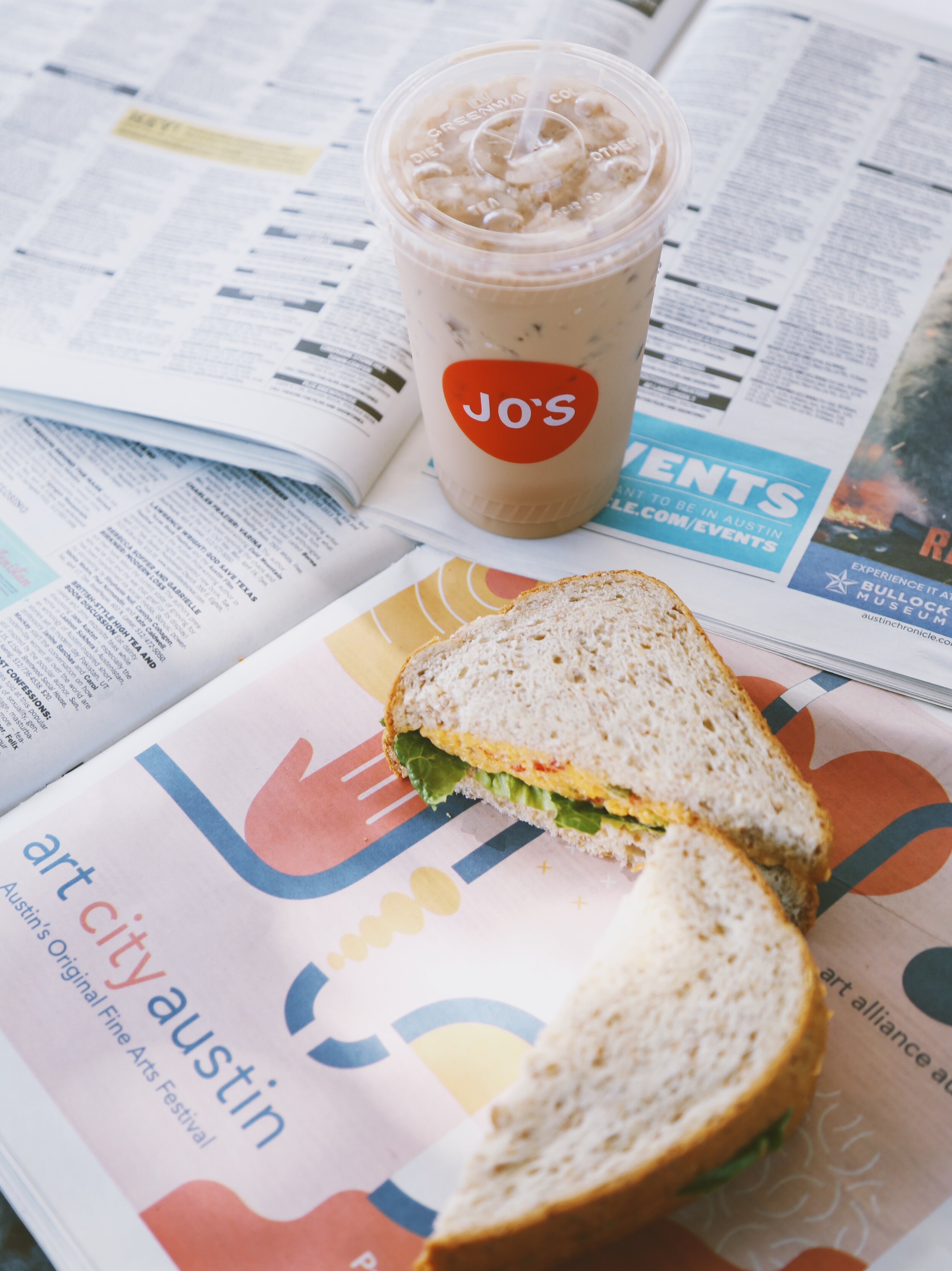  A Jo’s iced coffee and a sandwich atop an open newspaper. 