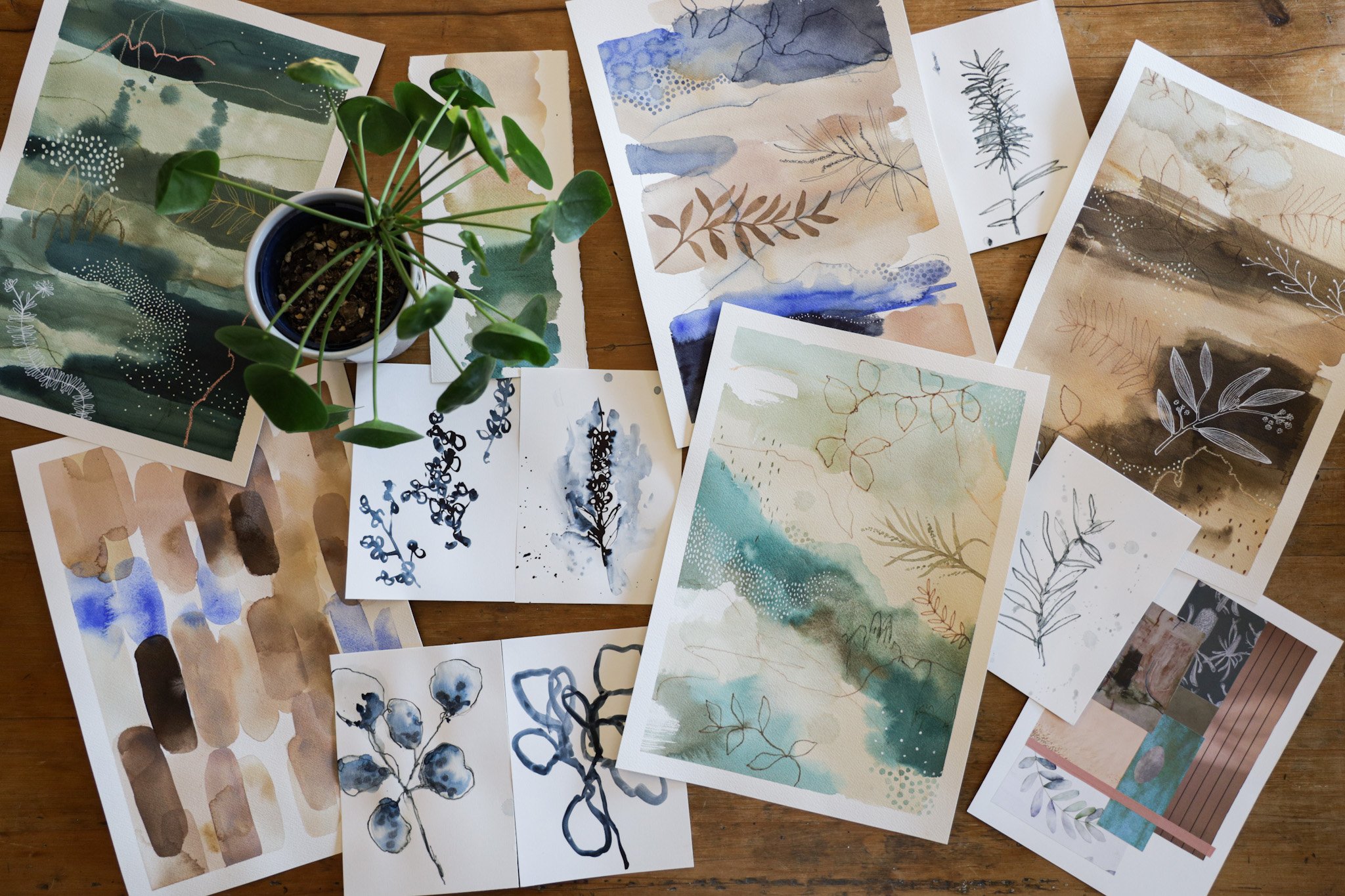  Bird’s eye view of finished botanical paintings on wooden table.  