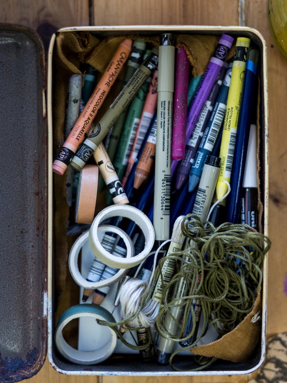  A tin filled with Neo Color II pastels and various other mixed media pencils and pens.  