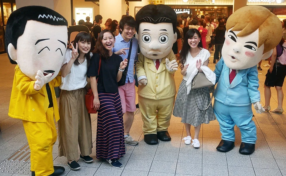 Yoshimoto fans get their picture taken with cartoonish representations of famous comedians.