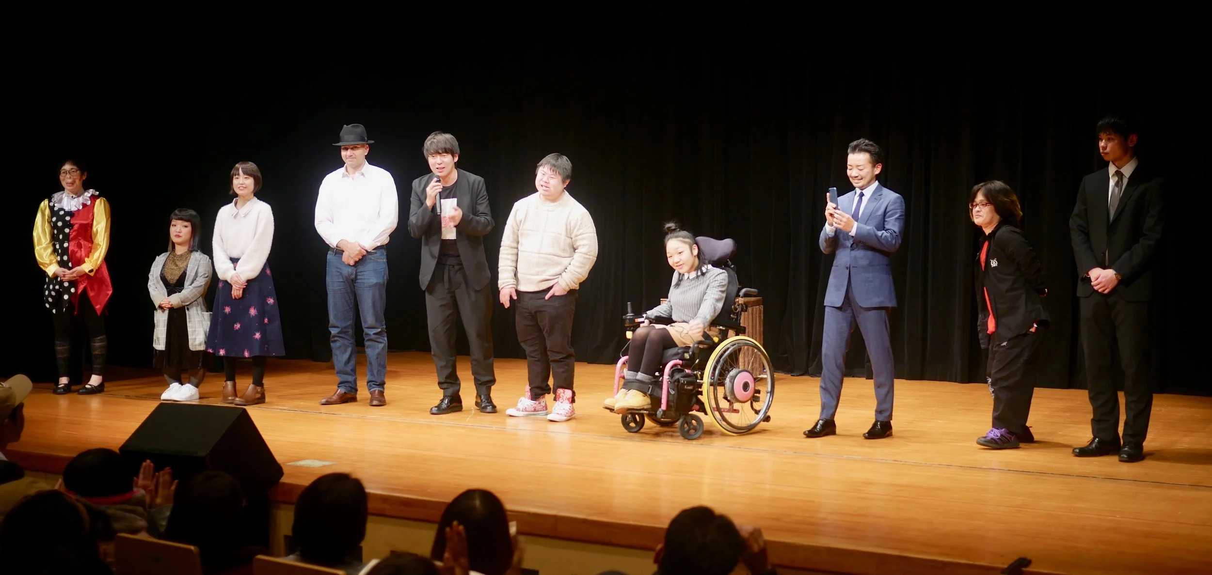 Performers take a curtain call with Muramoto Daisuke (in black with mic).