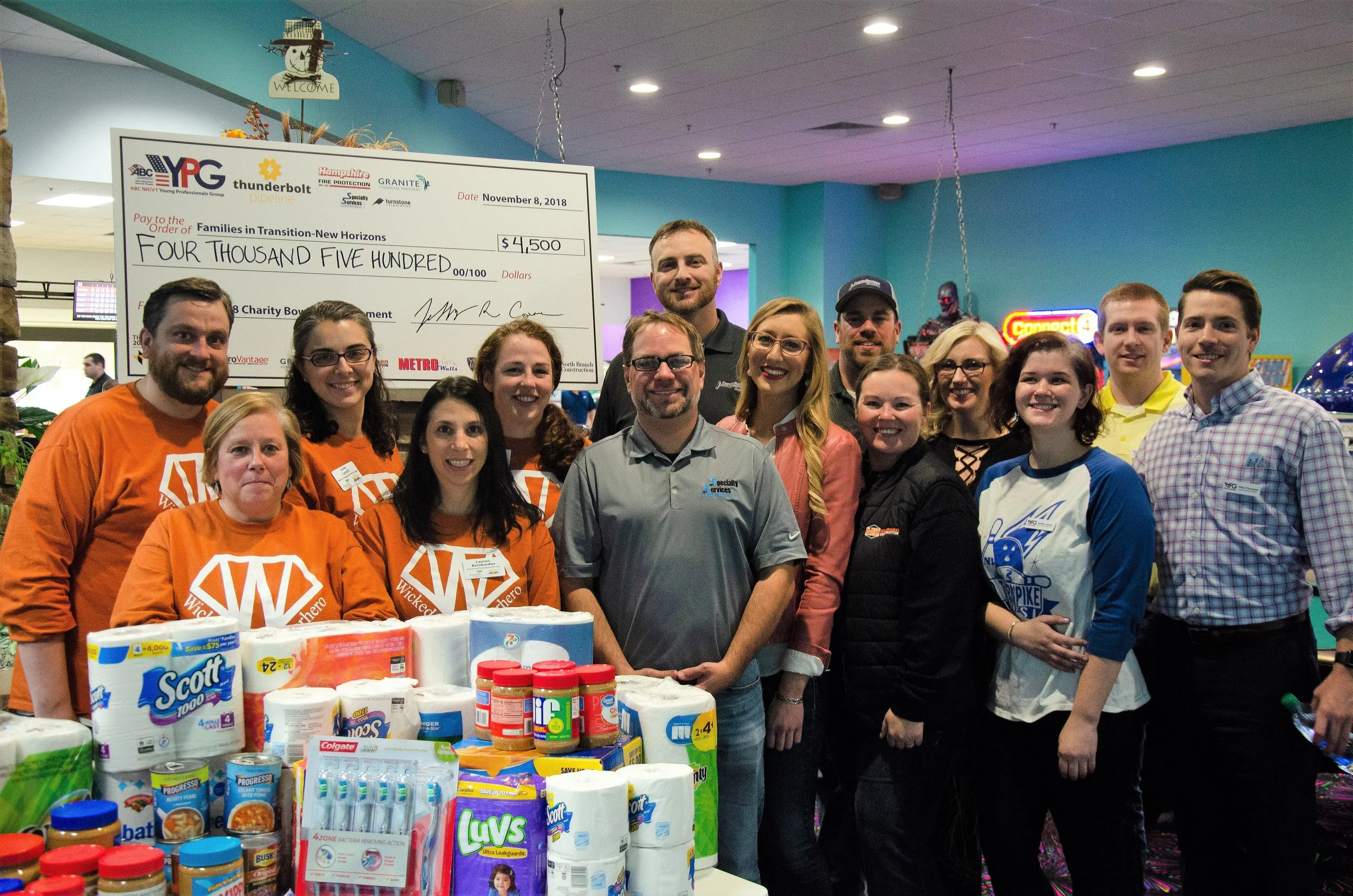 The ABC YPG Steering Committee presents a check for $4,500 and over $500 worth of pantry donations to Families in Transition-New Horizons