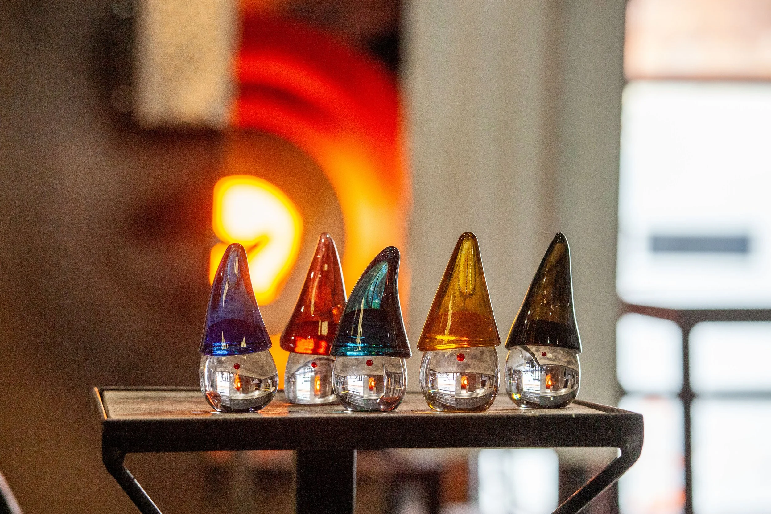 A group of our Glass Tomte Gnomes warming up by one of our re-heating furnaces.