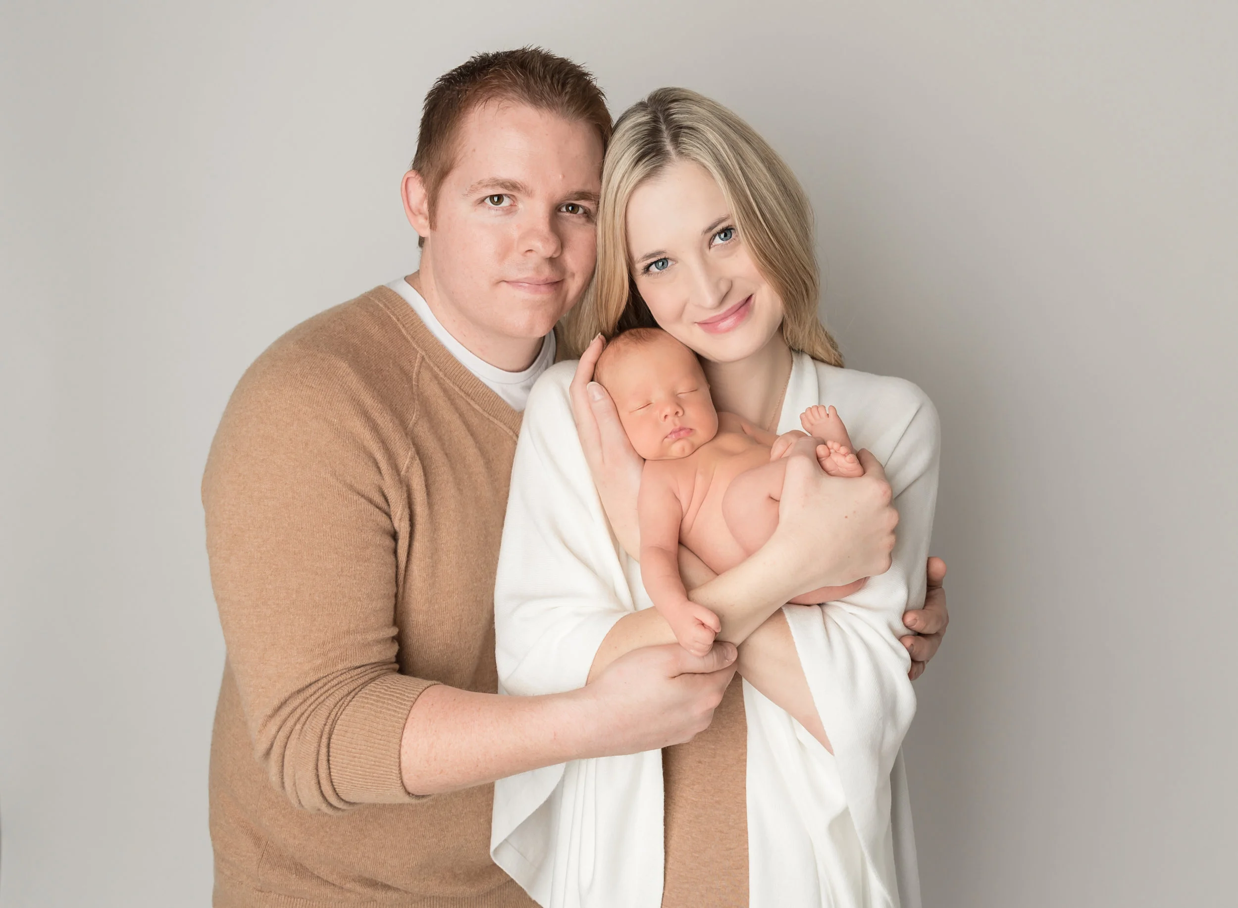 mom and dad holding newborn