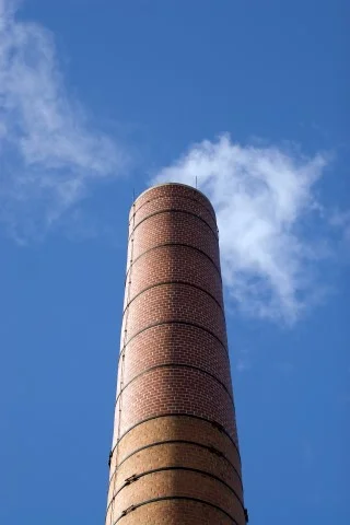 a-tall-brick-factory-smoke-stack-billowing-with-steam-and-smoke_BFzeGv80Bs.jpg