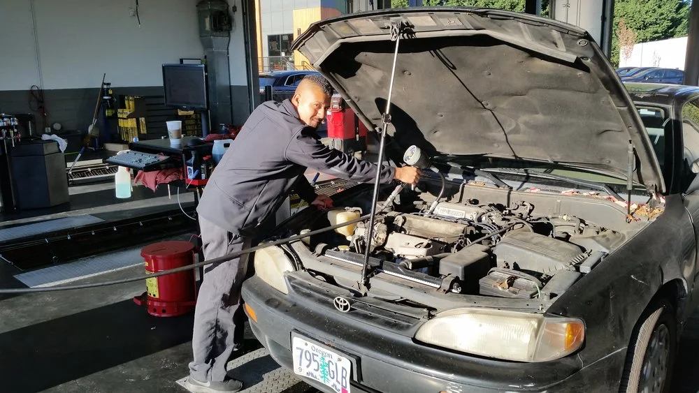 mechanic at Tigard Fast Lane Oil Change working on a car engine