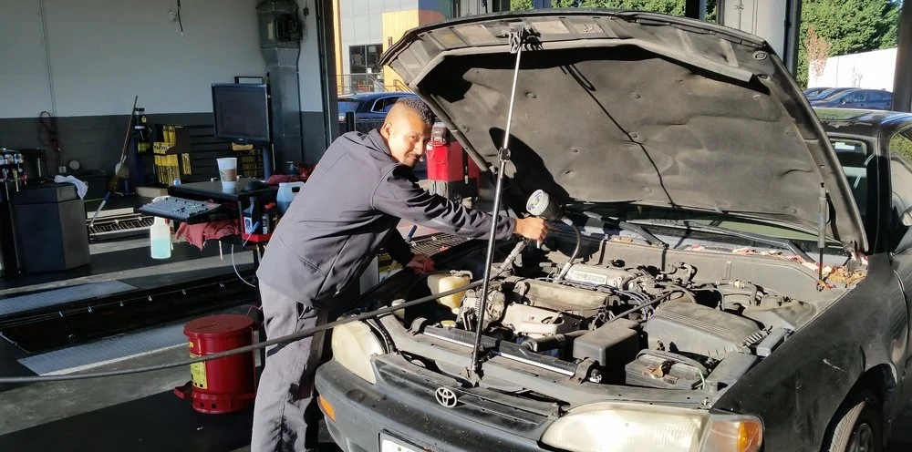 mechanic at Tigard Fast Lane Oil Change working on a car engine