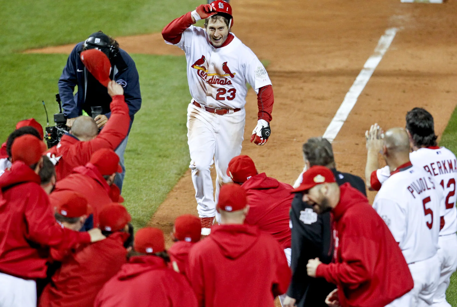  St. Louis Cardinals David Freese runs to home plate surrounded by his teammates after hitting the game winning home run against the Texas Rangers in the eleventh inning of&nbsp;Game 6 of MLB's World Series baseball championship in St. Louis, Mo.,&nb