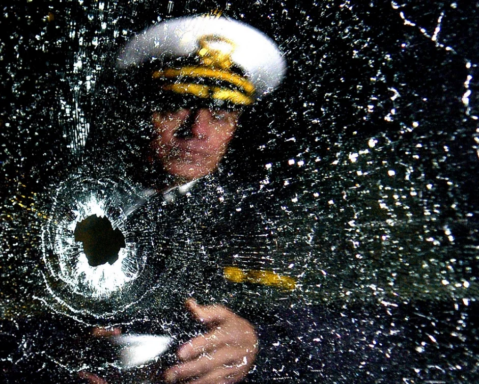 Cincinnati Police Chief Tom Streicher looks into the bullet-shattered window of one of his undercover vehicles following a police shooting in Cincinnati, Ohio, Friday, Dec. 2, 2005.  