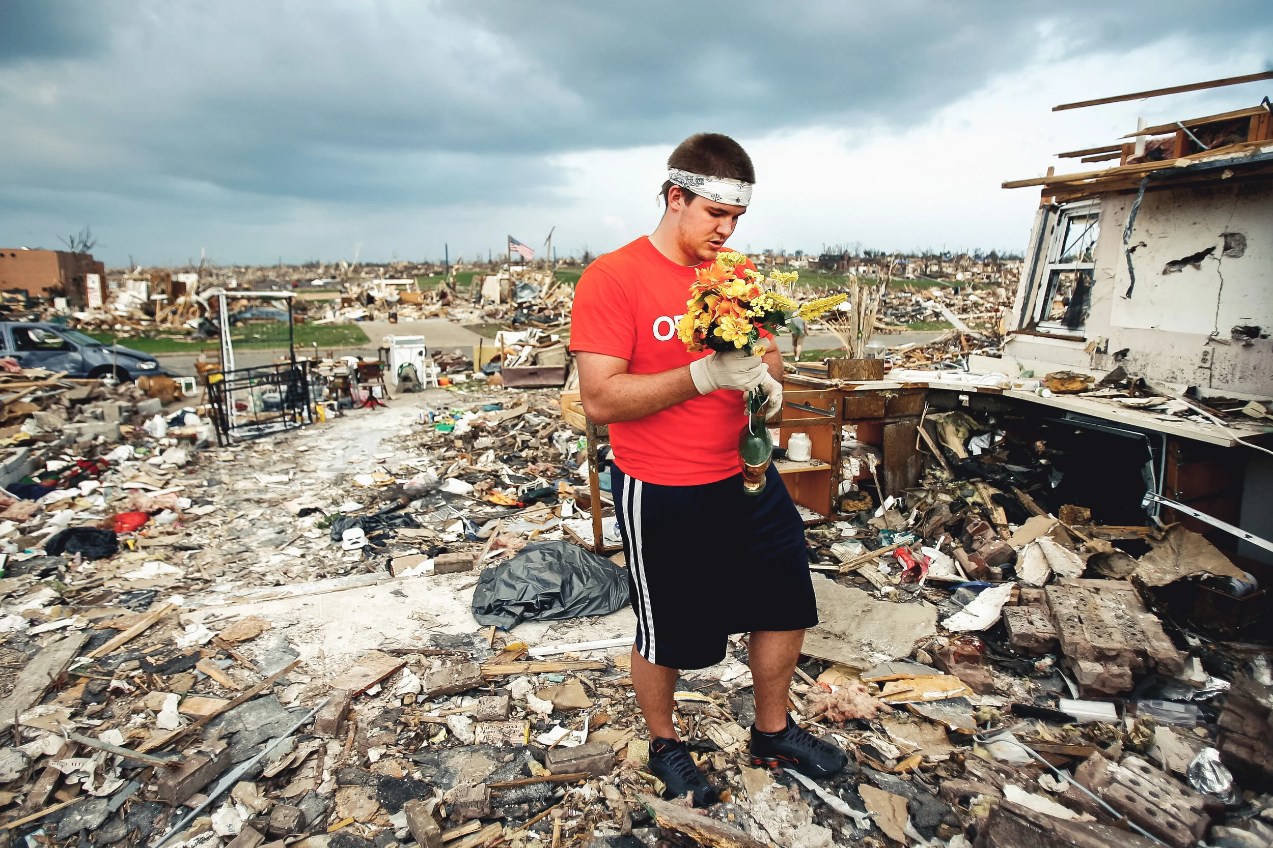 Volunteer Nelson Rumsey, of Quincy, Il., collects plastic flowers from a house destroyed by the tornado in Joplin, Mo., Tuesday, May 31, 2011, following the EF-5 that struck Joplin on May 22.