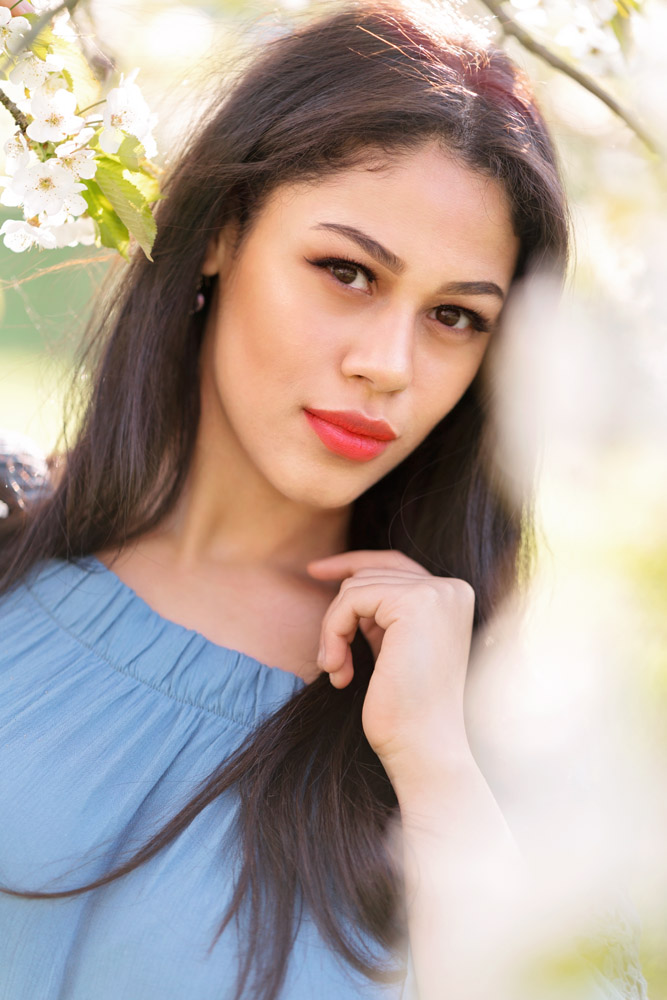  kaiserslautern Ramstein KMC Photographer beauty and portrait photography in Reichenbach-Steegen, Rheinland-Pfaly Germany. Beauty Portrait in Spring with beautiful dark hair girl in blue romper and white Cherry blossoms Close up by Sarah Havens 