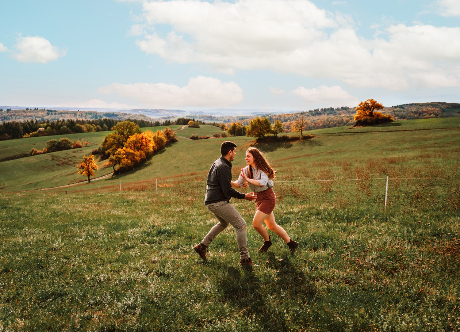  Young couple with new puppy dog enjoying the german country side in fall season with colorful leaves and rolling hills in Schweisweiler near Sembach air base. Photography by kmc engagement and family photographer Sarah Havens, Germany 