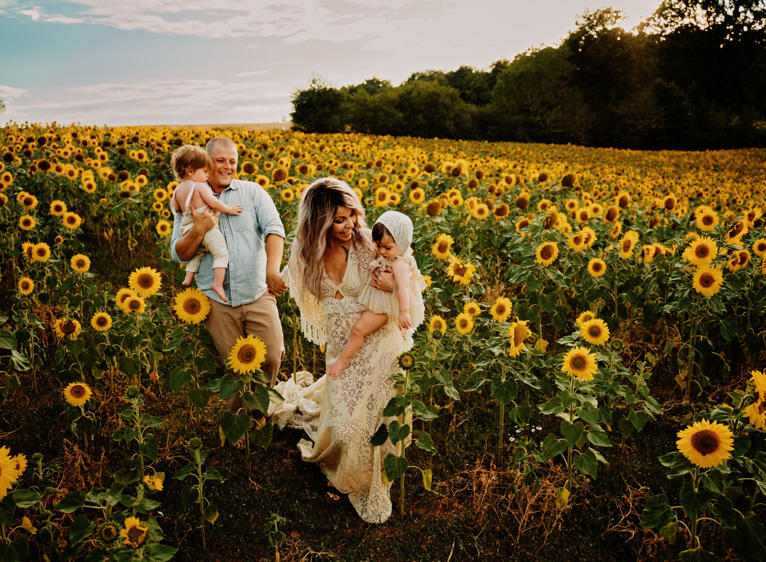  Beautiful family photo session in s big sunflower field. Young family with twins in boho outfits and flutter dress by ramstein kmc family photographer sarah havens 