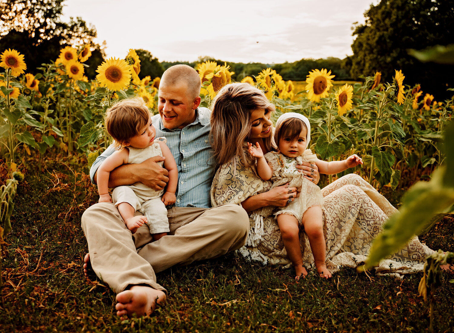  Beautiful family photo session in s big sunflower field. Young family with twins in boho outfits and flutter dress by ramstein kmc family photographer sarah havens 