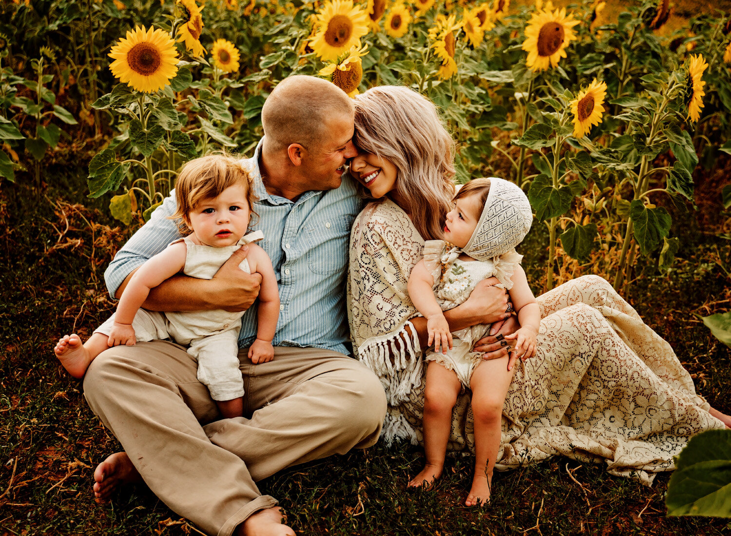  Beautiful family photo session in s big sunflower field. Young family with twins in boho outfits and flutter dress by ramstein kmc family photographer sarah havens 