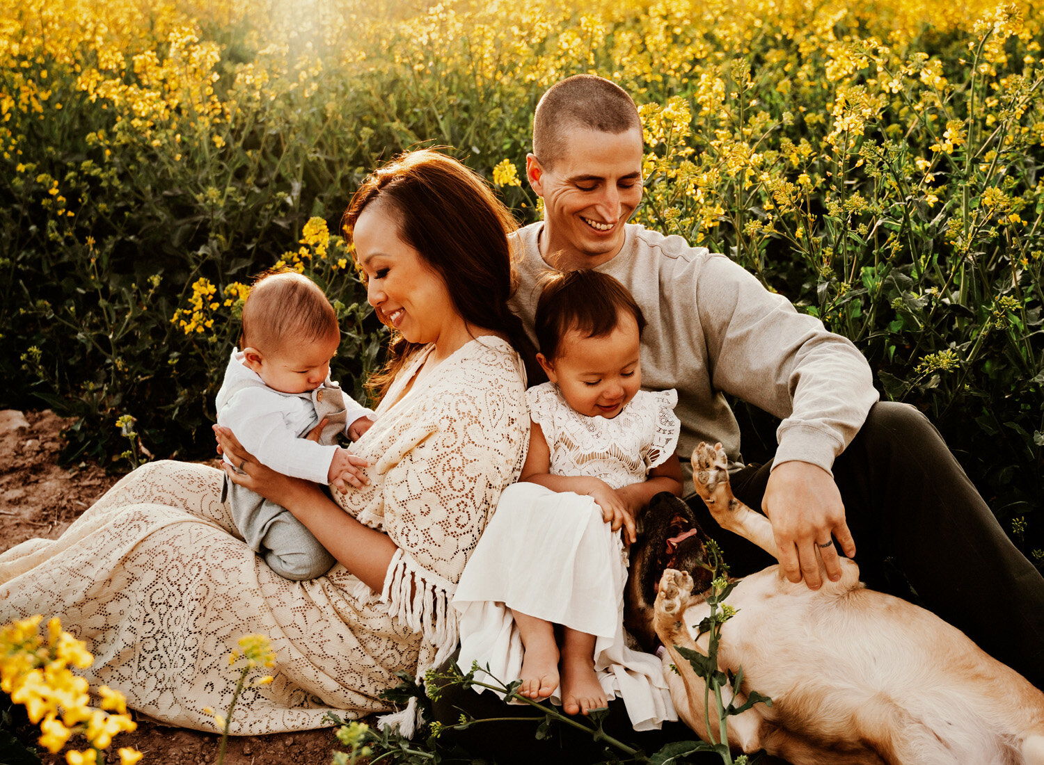  Beautiful Family with 2 small children in bohemian outfits playing in yellow rapeseed fields in Rheinland-Pfalz in the German country side. Lifestyle Family Photo Session by Sarah Havens, serving the Ramstein KMC and Kaiserslautern area. 