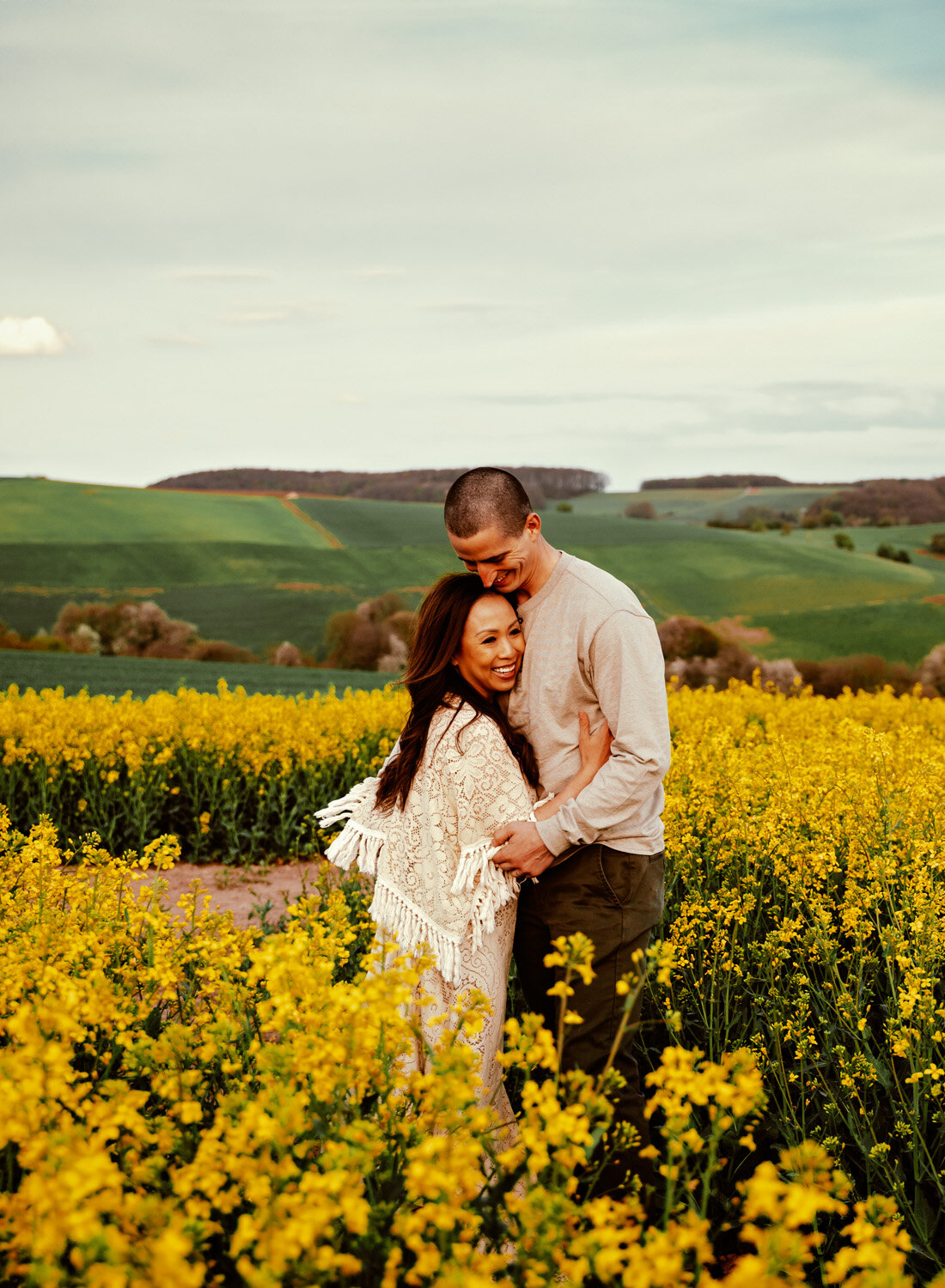  Beautiful Family with 2 small children in bohemian outfits playing in yellow rapeseed fields in Rheinland-Pfalz in the German country side. Lifestyle Family Photo Session by Sarah Havens, serving the Ramstein KMC and Kaiserslautern area. 