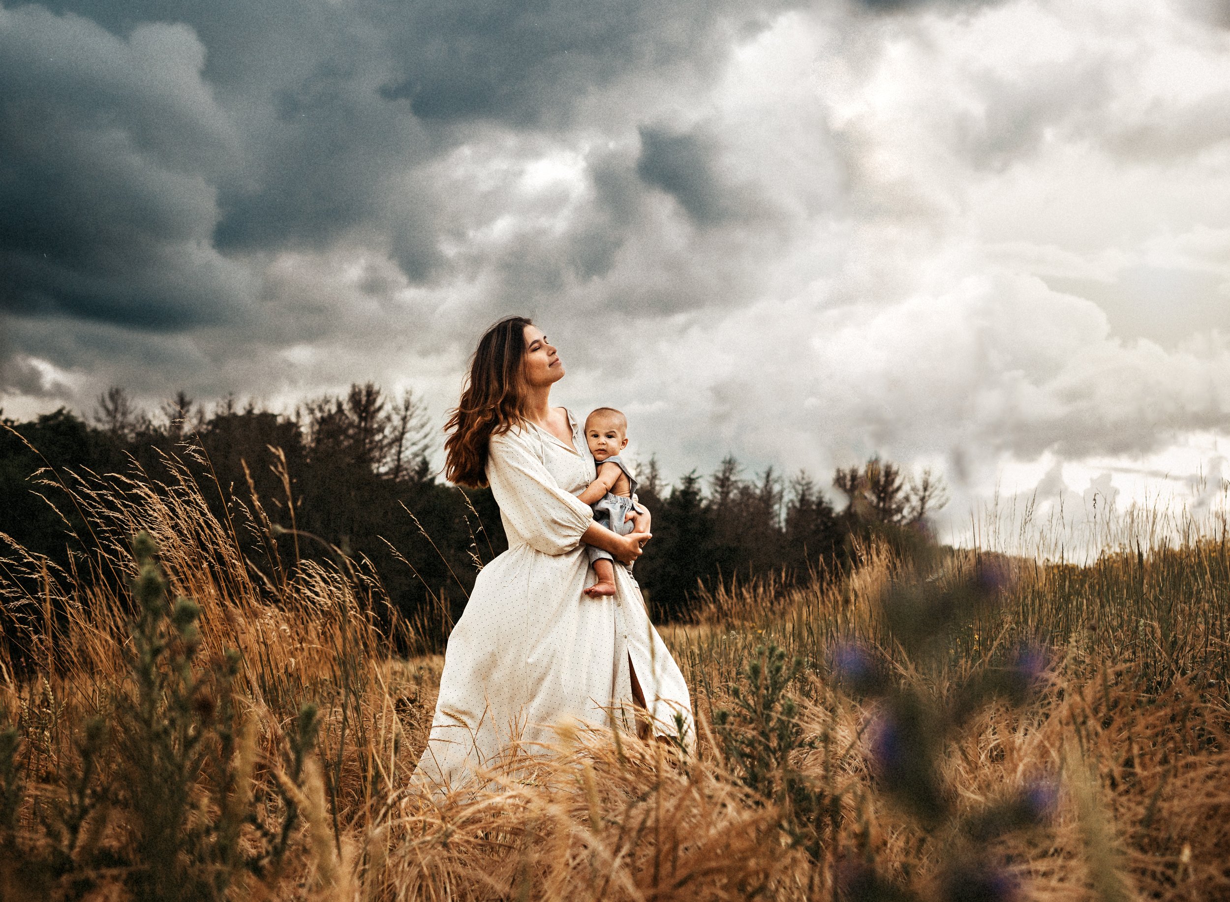 young-mother-and-baby-son-embracing-the-wind-in-a-dry-grass-field-motherhood-photography-in-ramstein-germany-by-family-photographer-sarah-havens-i.jpg