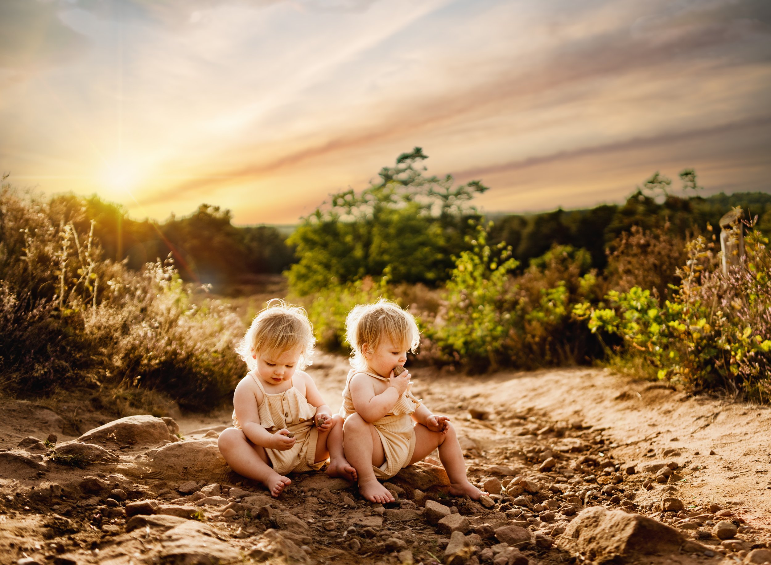 two-young-blonde-twin-babies-in-cute-overalls-playing-in-sandy-dirt-at-mehlinger-heide-at-sunset-by-family-photographer-sarah-havens-ramstein-kmc-germany.jpg