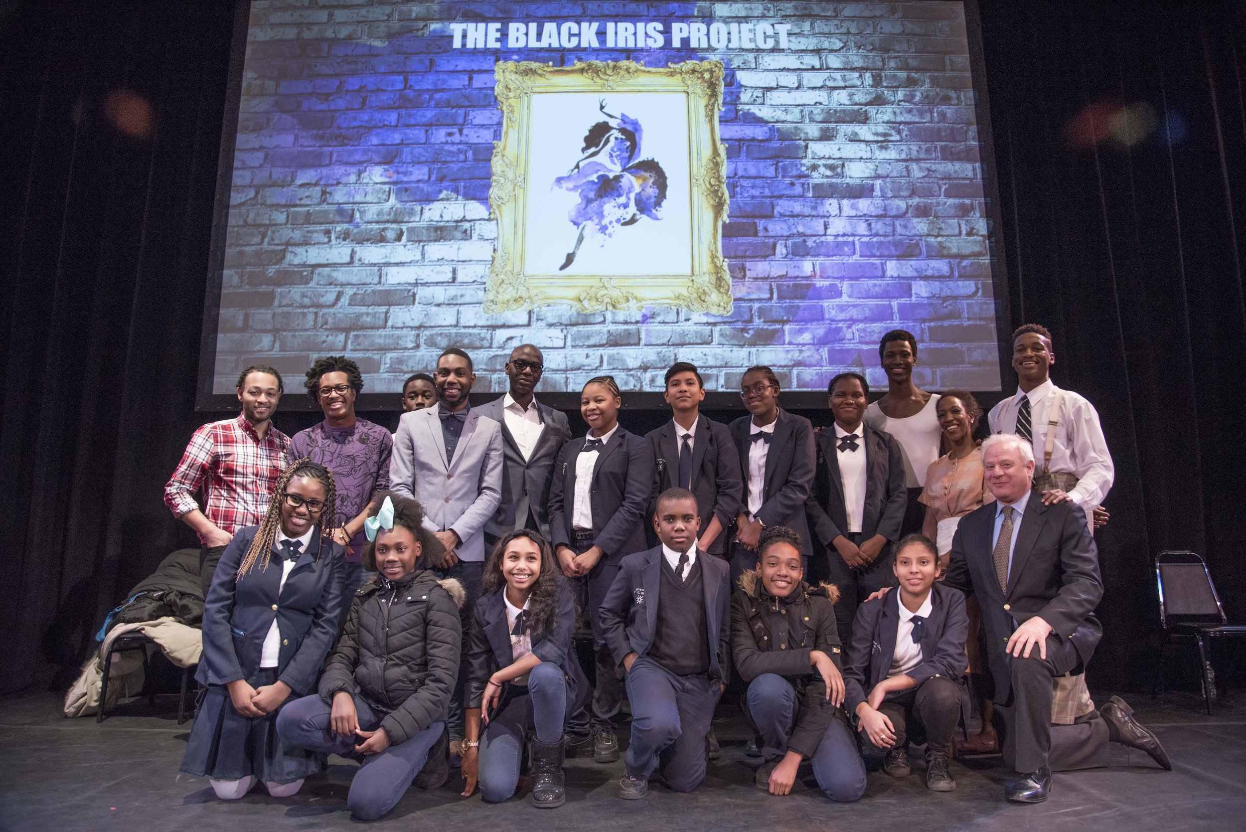 The Black Iris Project founder Jeremy McQueen (plaid shirt, left) Con Edison’s Alton Murray (center, glasses) and Town Hall president Tom M. Wirtshafter (right, kneeling) welcome students from P.S. 189 in Brooklyn to The Town Hall.