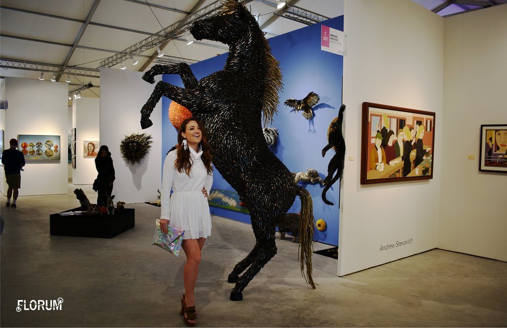 ART Miami 2017  ‘Horse’ by Colombian artist Federico Uribe that was designed in 2016  and entirely made of bullet shells.  Noelle Lynne wearing a white sweater by ethical Canadian brand  Fig Clothing , skirt by  Alexander Mcqueen , thrifted clutch,  white finger frolics earrings by REDGREGOR that are made of upcycled plexiglas , and  sustainable luxury shoes by Viktor & Rolf from online consignment shop the Real Real (Click  HERE  to get $25 off your first purchase on The Real Real)