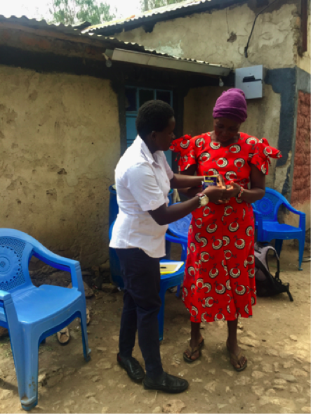 Eggpreneur employee Ann teaches Fridah how to read the instructions on the antibiotics for her chickens