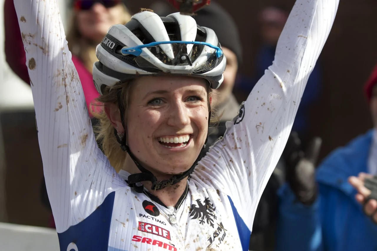 Ellen Noble lifts her bike in victory after crossing the line for her second U23 Cyclocross National Championship.