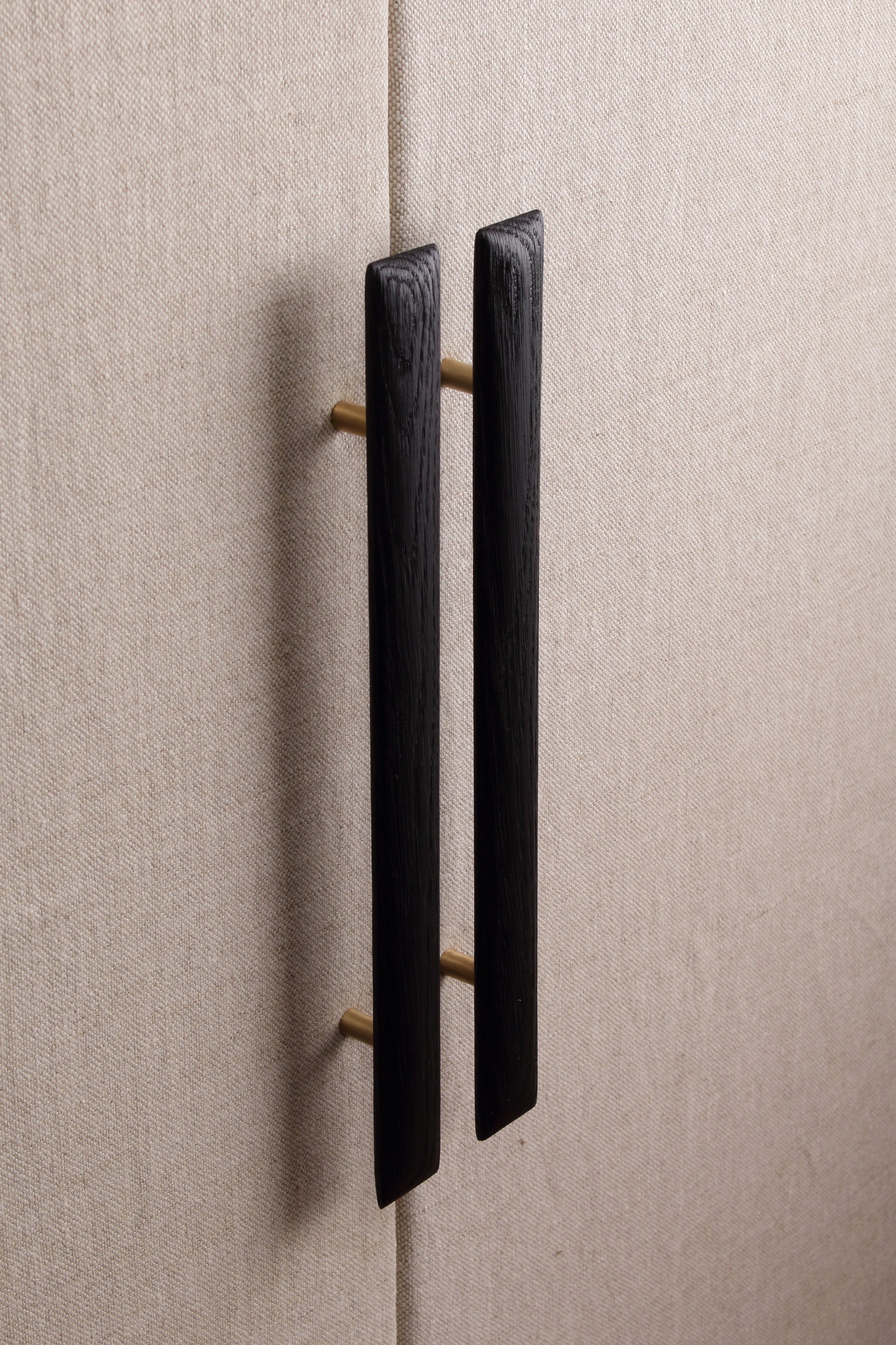 Furniture, cabinet and wardrobe long pull handle in scorched wood timber, brass and bronze detail. Soft shaped front.