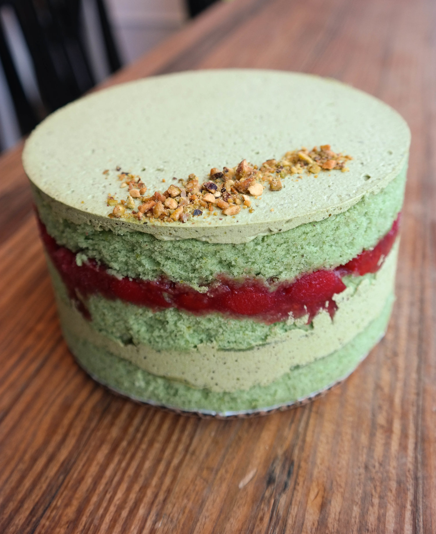   Pistachio Cake - pistachio cake layered with pistachio buttercream and cherry compote, sprinkled throughout with toasted pistachios 