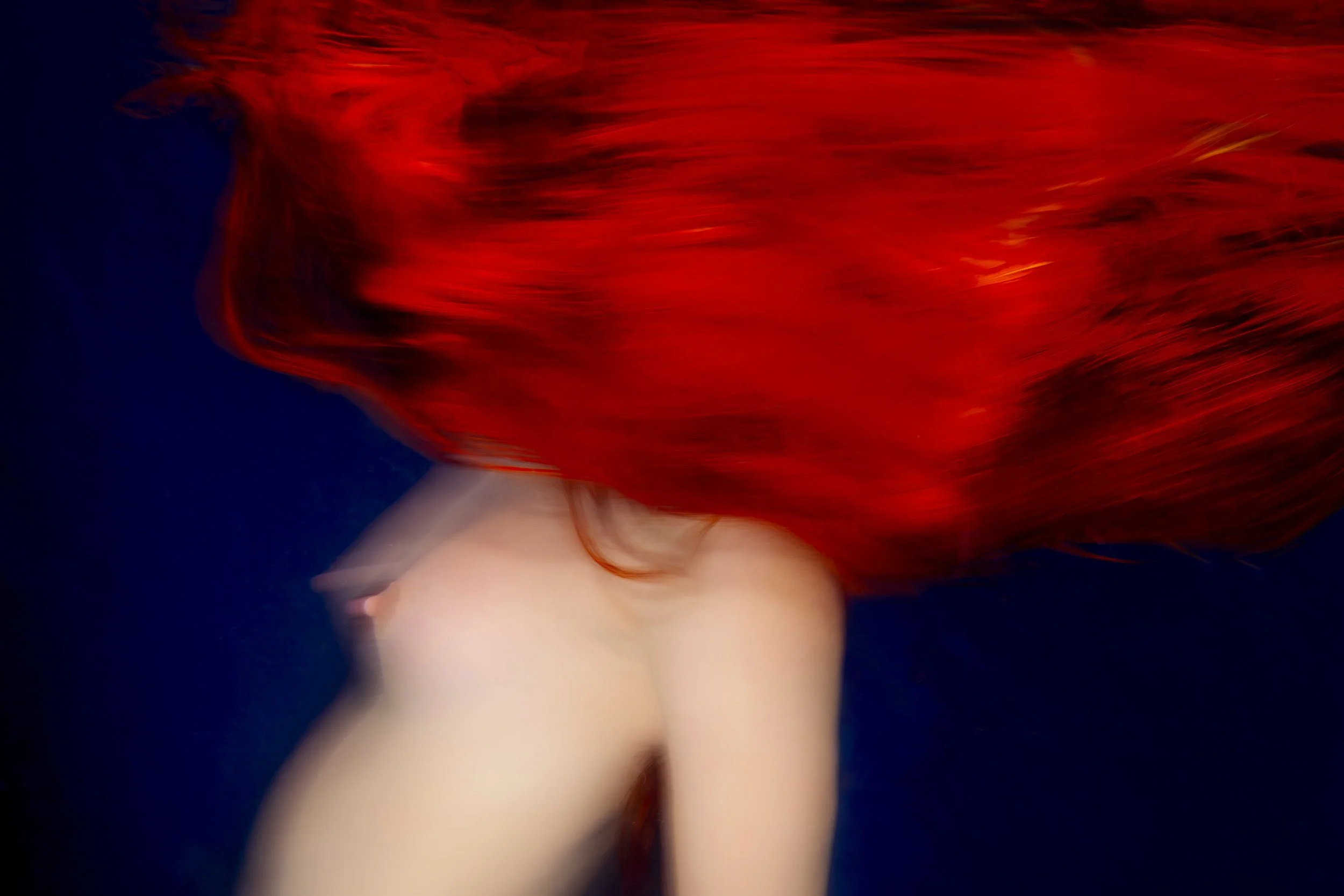 Crimson Siren - 'A bold siren emerges, her crimson presence commanding the depths' from the Venus Underwater Portraits, fine art photography prints by Ted Grambeau.