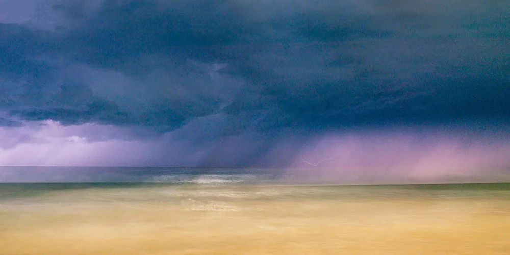 Long handheld exposure of a lightning storm over Currumbin Beach, a painterly seascape by Ted Grambeau.