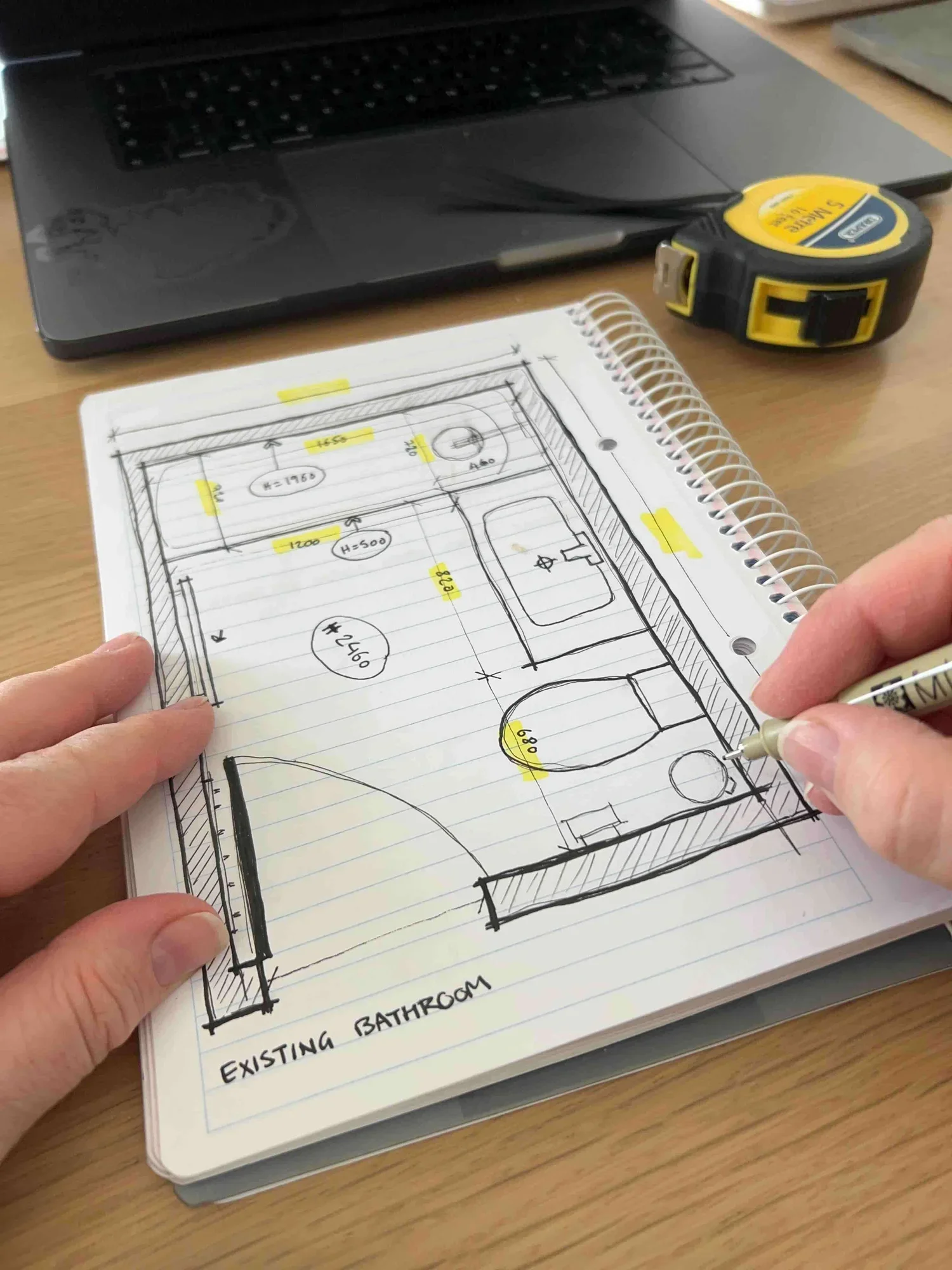 Sonia Nicolson measuring an existing building on site with a scale ruler and sketchbook, offering professional architectural survey services for small projects and renovations