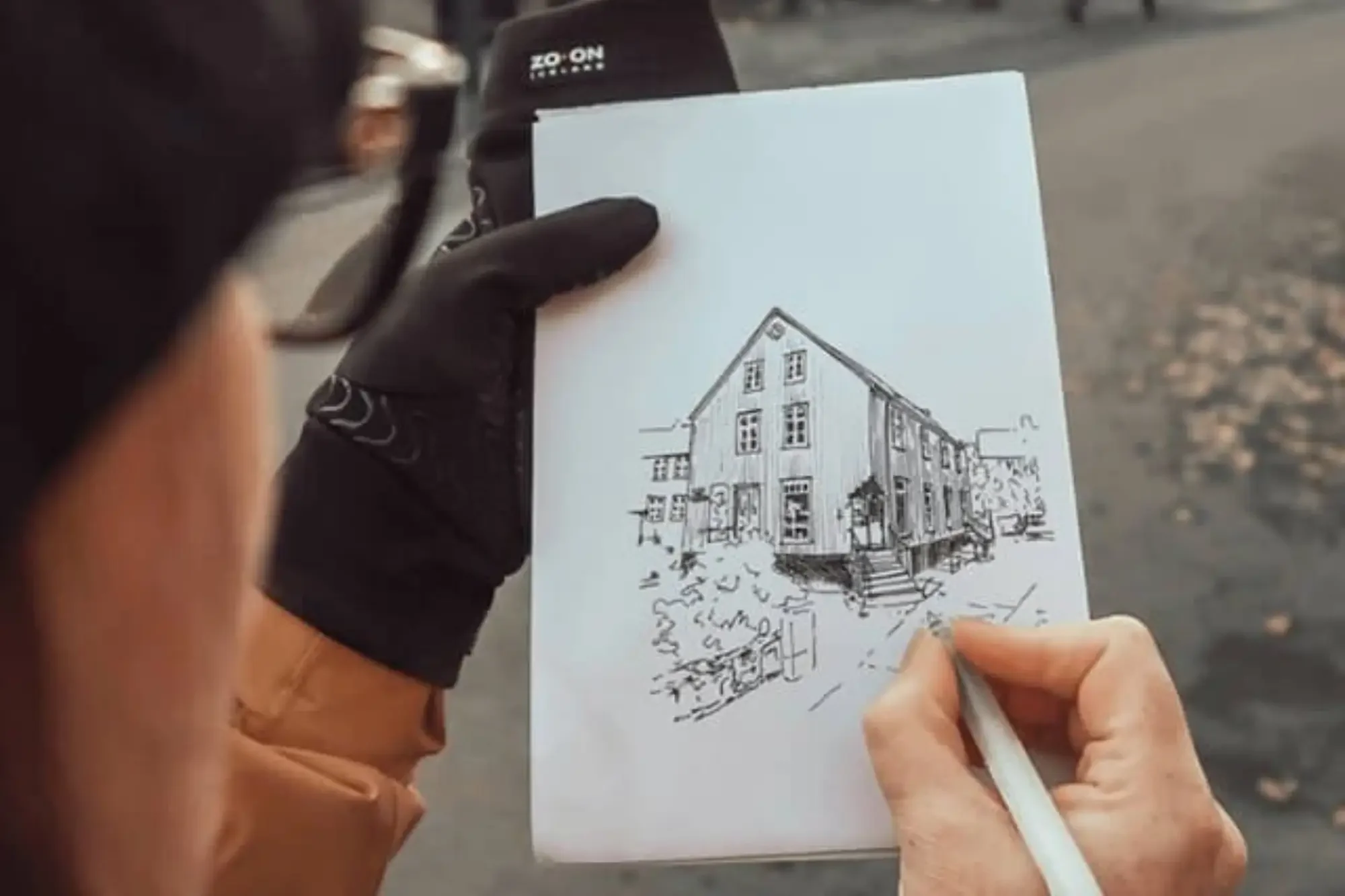 Architect sketching a residential building by hand in an urban street scene