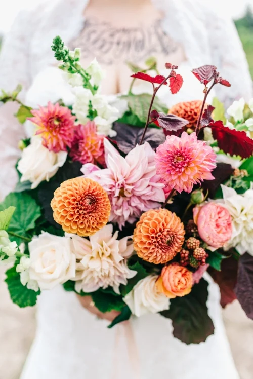 Garden Style (veldboeket) bruidsboeket met dahlia's, garden rozen en onrijpe zwarte bessen. Foto: Raisa Zwart Photography