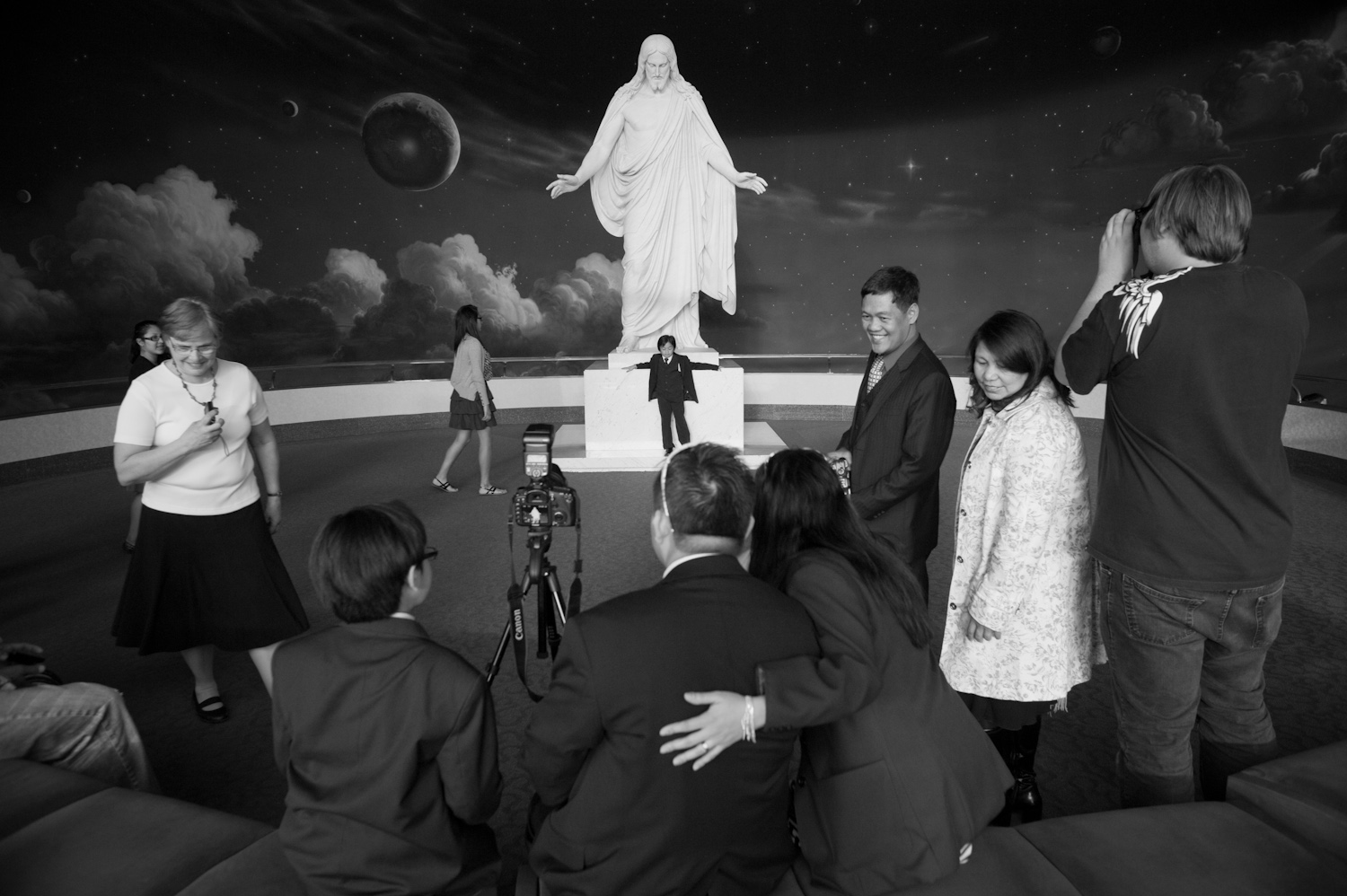 Tourists and members of The Church of Jesus Christ of Latter-day Saints pose in front of the Christus statue during the semiannual LDS General Conference at Temple Square in Salt Lake City, Utah.