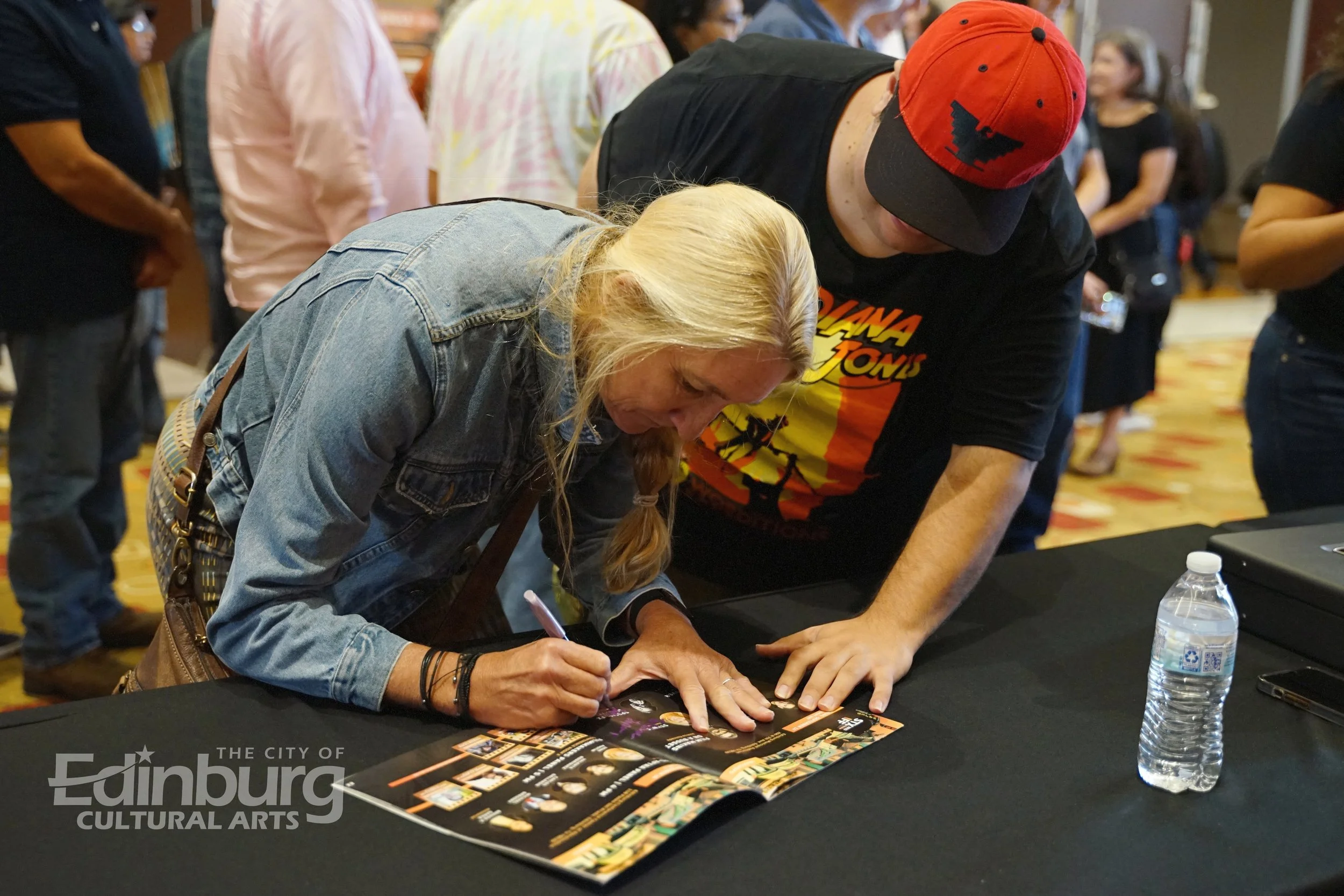 Jane Austin autographing a STXIFF program 