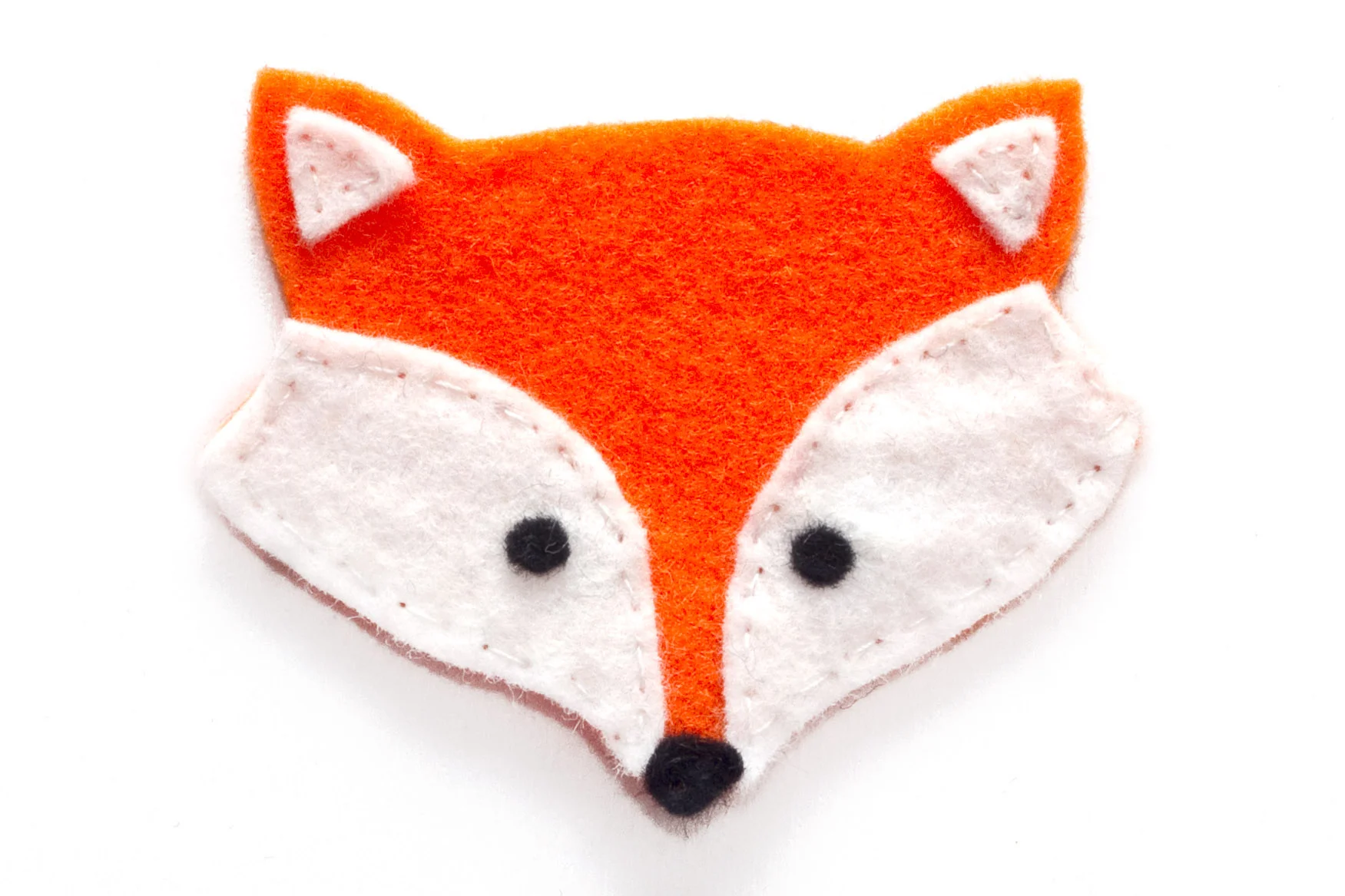 Step 2. Sew the black circles onto the white felt using the black cotton. Then sew all of the white felt pieces onto one of the orange felt shapes using white cotton. Then sew the black nose on with black cotton.